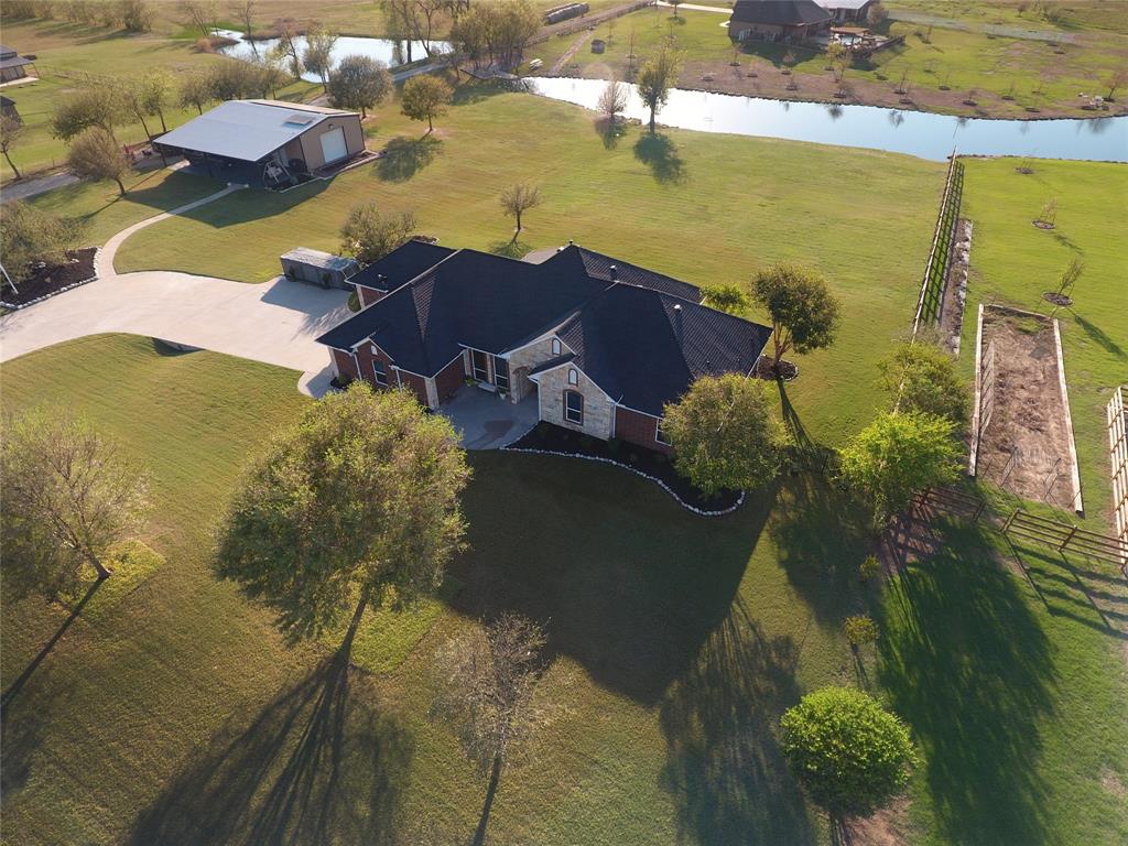 An Amazing 2.179 acres in the sought after area of Lake Ray Roberts. This corner lot is located on a beautiful crystal blue body of water loaded with large -mouth black bass and catfish. The estate boast a gorgeous single story recently updated 4 bedroom 3.5  bath home. The properties lush grounds creates a tranquil backdrop for elegant country living. The home has a recently added hail resistant roof, gutters, and a newly installed insulated garage door. The house has solar panels located on the workshop that keep the electricity bills lower throughout the year, especially during the hot summer months. The land has an unbelievable heated 30X50 workshop with a 20X50 paved overhang for extra parking or relaxing in the morning with a cup of coffee or in the evening enjoying the sunset overlooking the crystal clear water. The workshop includes an unbelievable office, entertainment room with AC and a bathroom. The extremely well maintained home boast newly installed quartz countertops in the kitchen and bathrooms along with new back plash's to match. This estate also includes a  rock fireplace complete with gas logs, new lighting, ceiling fans, gas stove top, brand new 5 ton energy efficient AC unit, extra parking, sprinkler system, covered patio, and gorgeous views of the water.  There are so many upgrades and extras to see in this estate. This is a MUST see!