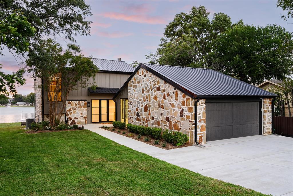 Experience elevated waterfront living at 313 Scenic Drive, where 100 feet of shoreline on Lake Ray Hubbard and panoramic water views create an extraordinary lakeside retreat. Completely renovated from top to bottom with high-end finishes and timeless modern design, this stunning residence offers luxury, comfort, and breathtaking scenery at every turn. Beautiful light wood flooring flows throughout the home, while expansive walls of windows and glass doors showcase spectacular lake views and fill the interior with natural light. The open concept main level features a spacious living room with a fireplace, dining area, and a beautifully appointed kitchen complete with quartz countertops, custom cabinetry, built in refrigerator, designer fixtures, and a large island with breakfast bar seating. A charming breakfast area with built in cabinetry. A versatile flex space on the main level is currently configured as a custom bunk room with four built in bunks, ideal for hosting family and guests, while a full bath adds convenience and functionality. Upstairs, access to a private balcony overlooking the water offers a charming place to relax. The private primary suite serves as a peaceful retreat with sweeping lake views and a luxurious ensuite bath featuring dual sinks and a stunning glass enclosed walk in shower. Two additional bedrooms and a full bath provide comfortable accommodations. Outdoor living is equally impressive. A spacious deck extends across the rear of the home, providing the perfect setting for dining, entertaining, or simply enjoying the tranquil surroundings. The backyard leads directly to the shoreline, offering an unparalleled connection to Lake Ray Hubbard. This exceptional property combines designer finishes, modern elegance, and a premier lakefront setting just minutes from shopping, dining, highly rated schools, and convenient access to Dallas. A rare opportunity to own a fully reimagined waterfront home with unforgettable views.