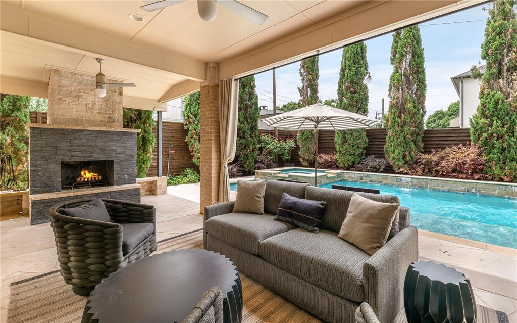 Situated in one of Lakewood’s most serene and walkable pockets, this beautiful home blends rich, moody design with warm, inviting living spaces just moments from White Rock Lake, the SoPac Trail, and highly sought-after Lakewood Elementary. The outdoor living experience is exceptional, made to feel like a private resort tucked into one of Lakewood’s quietest and most peaceful settings. A covered patio with fireplace creates a true year-round outdoor living room, overlooking the pool and spa with an oversized tanning deck and tranquil waterfall features. The outdoor kitchen is fully equipped with a built-in grill, Big Green Egg, and two generous seating areas. Just off the patio, a convenient half bath adds functionality for pool days. The yard is framed with lush landscaping and enhanced by a sliding rear gate for added privacy and expanded yard space. From the moment you step inside, the expansive foyer and soaring two-story ceilings create an unforgettable first impression, flooding the home with natural light. The home features a handsome office with tall ceilings and custom built-ins, a formal dining room anchored by a striking glass wine cellar wall, and a purposeful mud room and built in desk area. The breakfast nook has been reimagined as a cozy lounge-style retreat overlooking the outdoor living area, creating the perfect setting for morning coffee or evening cocktails. Upstairs, an oversized media and game room combination offers flexibility, featuring a projector, bar area, and mini fridge ideal for movie nights, entertaining, or play space. Recent updates since 2024 include a brand new class 4 roof, all new cool stone on the patio, new cabinet hardware in kitchen and all baths, all new plumbing fixtures, new thermostats, all new light switches, new microwave, some new windows, new bathroom grout throughout, new garage storage systems. New washer and dryer from 2024 and media room projector stay with the home.