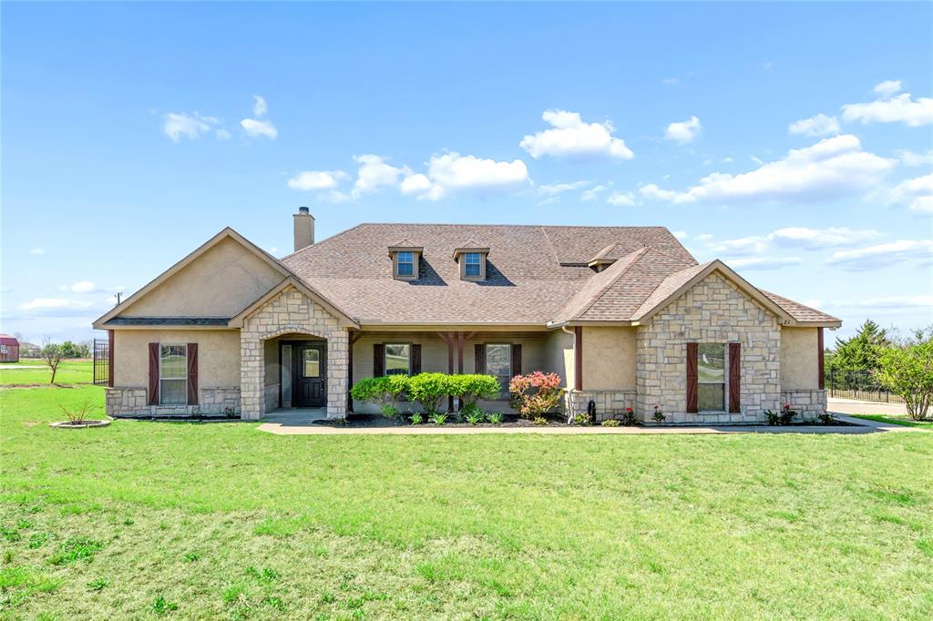 Stunning custom 1.5-story home situated on 1.7+ acres in the gated community of Country Ridge, ideally located on a quiet cul-de-sac. This beautifully designed home features a charming stone façade, covered front porch, and exceptional craftsmanship throughout, including hardwood floors, crown molding, built-ins, arched doorways, and custom trim. The spacious family room showcases a striking stone wood-burning fireplace and built-ins, creating a warm and inviting atmosphere. The chef’s kitchen offers marble countertops, a stylish backsplash, double ovens, a large island, breakfast bar, and custom cabinetry with pull-out drawers and a dedicated spice cabinet, all open to a cozy breakfast area. The private primary suite features a sitting area and a luxurious bath, providing a perfect retreat. A dedicated office offers a quiet space for work or study. Two generously sized secondary bedrooms and a full bath are conveniently located on the first floor. Upstairs features a large game room, perfect for entertaining or additional living space. Enjoy outdoor living with both a covered patio and screened-in patio overlooking a super large backyard complete with a fire pit. Additional highlights include a spacious utility room with cabinets and sink, plus a 20x20 storage building with an overhead door. A rare opportunity to own a custom home on acreage with privacy, space, and upscale features.