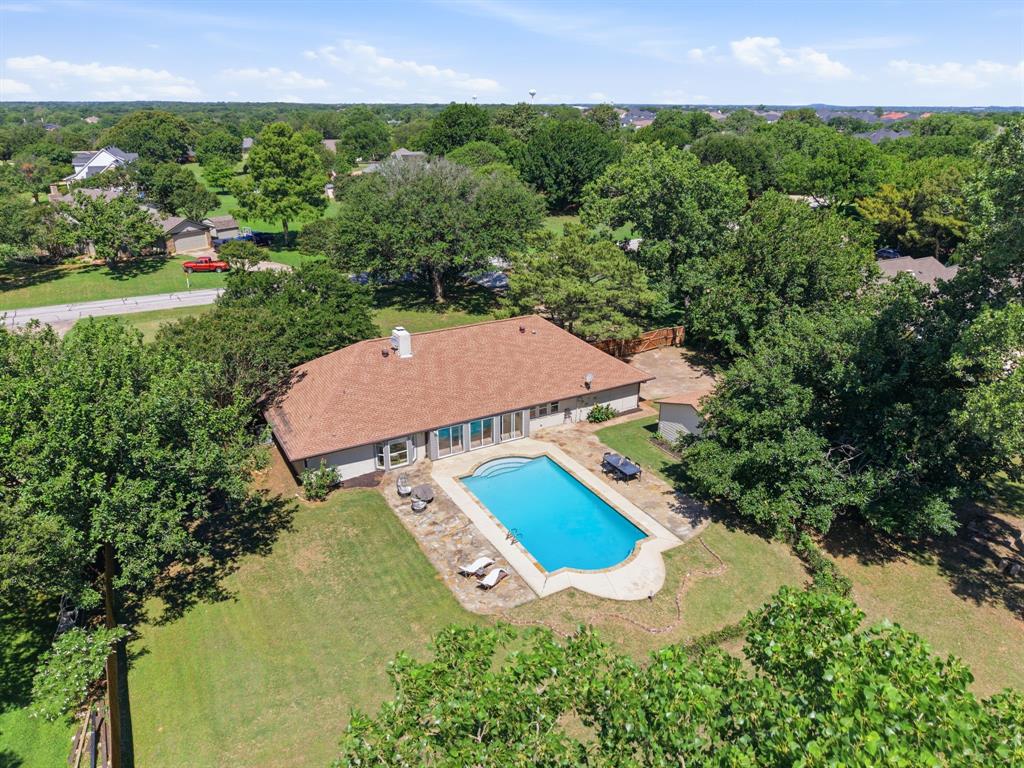 WELCOME HOME! Nestled on nearly one acre in highly sought-after Double Oak, this beautifully renovated 4-bedroom, 3-bath home with office offers the perfect blend of modern updates, functional living space, and peaceful surroundings.
The thoughtfully designed layout offers multiple living and entertaining spaces, including a spacious family room with a wood-burning fireplace, a game room, and an upstairs media room. Walls of windows fill the home with natural light, highlighting the open flow of the main living area, where a floor-to-ceiling brick fireplace and custom wood beams add warmth, depth, and character throughout.  Additional improvements include fresh interior and exterior paint, new luxury vinyl plank flooring, new carpet, and designer lighting throughout.
The fully remodeled kitchen is a true showpiece, featuring custom white oak cabinetry, Quartzite countertops, a marble backsplash, double ovens, a pot filler above the stove, a dedicated coffee bar off the breakfast nook, a white oak pantry, and an impressive 9-foot island with abundant storage and space for casual dining. An enclosed climate-controlled sunroom overlooks the backyard pool and provides the perfect setting to enjoy your morning coffee year-round. The primary suite serves as a private retreat, featuring bay windows overlooking the backyard, direct outdoor access, a custom closet system, a spacious walk-in shower, soaking tub, and statement tile that adds a designer touch to the ensuite bath.
Outside, enjoy the privacy and space of a nearly one-acre lot complete with a sparkling pool, mature trees, detached two-car garage, storage shed and plenty of room to relax, entertain, or embrace a little homestead living. 
Located within Lewisville ISD, this property combines the charm of country living with the convenience of nearby shopping, dining, and entertainment.SELLER OFFERING $7,500 BUYER CREDIT! ASK FOR DETAILS