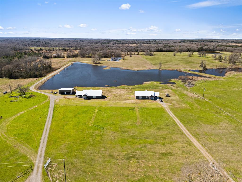 Experience the perfect blend of space, privacy, and opportunity with this exceptional 16.25-acre estate featuring 2 beautiful homes and a stunning large pond. Whether you're seeking multi-generational living, income potential, or a private retreat, this unique property offers endless possibilities. Enjoy serene water views, wide-open land, and the flexibility to live, invest, or expand—all in one remarkable setting.You will LOVE the huge insulated shop. 385 offers 2 bedrooms 2 baths  with 1650 sf and 349 offer 2bedrooms 2 baths with 1486 sf. Buy 2 homes together or 349 CR 3104 can be bought separately with 2 acres for $309,000.  This would be an wonderful place to add an event center and rent out.  So many options for this amazing property!