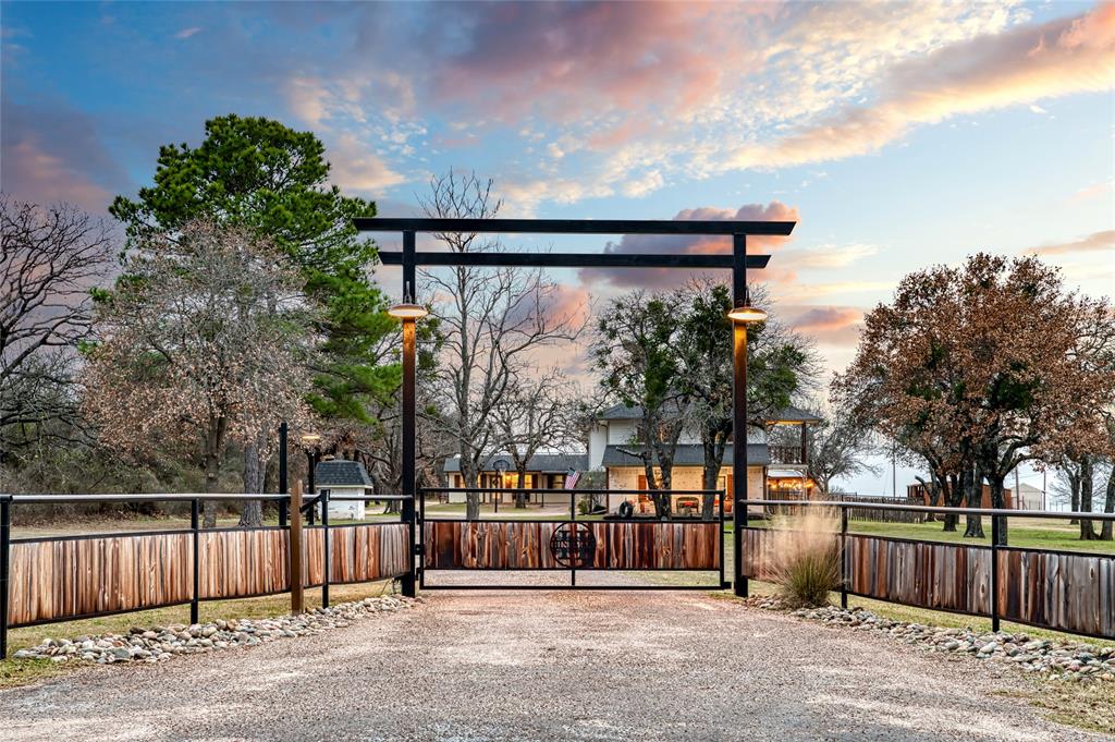 Unrestricted Ag exempt equestrian ranchette located in the highly sought after Brock ISD. This exceptional 5.44 acre property offers a rare combination of functionality, flexibility, and lifestyle, making it ideal for horse enthusiasts, multi generational living, or a private country retreat.
The property is fully fenced and cross fenced with sandy loam soil and mature oak trees. A gated entrance leads to a circular drive with ample parking, providing both convenience and strong curb appeal.  Equestrian improvements are turnkey and thoughtfully designed for efficient daily use. Features include a 140 by 275 panel arena, ten oversized 20 by 40 runs with water, four loafing sheds covering multiple runs, and two fully covered stalls. The layout allows for easy management and optimal horse care.  The main residence is a beautifully updated farmhouse style home featuring a large shaded front porch and a wood burning fireplace. Interior updates include upgraded plumbing throughout. The primary suite offers dual walk in closets and a private deck overlooking the property.  A separate one bedroom one bath guest house with a full kitchen provides excellent flexibility for guests, extended family, or potential rental income. Outdoor living is a true highlight with a resort style pool area renovated in 2021. The space includes a cabana with bar and kitchen, pergola, stone fireplace, and fire pit, creating an ideal setting for year round entertaining.  Additional improvements include a 30 by 40 shop with 220 volt service, well water, and an on site septic system, offering both functionality and independence.
This property presents a rare opportunity to own a fully improved and versatile ranchette in one of the most desirable areas of Parker County.