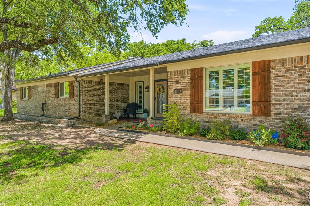 Welcome to this beautifully updated brick home that combines classic charm with modern upgrades, all tucked into a desirable, well-established neighborhood. With 3 spacious bedrooms, 2.5 bathrooms, and a thoughtfully designed open-concept layout, this home is truly move-in ready and perfect for families or anyone who loves to entertain. Step inside and immediately feel at home in the warm, inviting living area, featuring a cozy wood burning fireplace, vaulted ceilings and elegant plantation shutters that let in plenty of natural light. The heart of the home is the stunning kitchen, complete with a large center island perfect for gathering around, a deep farmhouse sink framed by corner windows, stylish finishes  and ample cabinetry. The private master suite offers a quiet retreat, while the two additional bedrooms are connected by a convenient Jack-and-Jill bathroom ideal for growing families or guests. A bonus room provides flexibility for an additional dining area, second living room, playroom, or home office, the choice is yours! The roomy laundry room features extra countertop space and built-in storage for ultimate functionality. Enjoy peace of mind with a brand new roof and gutters, new HVAC system (inside and out), and a new cedar privacy fence that encloses the backyard oasis. The double-car garage offers secure parking and storage. Outdoors, mature trees shade the front and backyards, and the back patio provides the perfect setting for relaxing or hosting gatherings. For garden lovers, stock tank-style galvanized raised beds are ready for your green thumb. With charming curb appeal, a prime location near schools and thoughtful updates throughout, this home truly checks every box. Don’t miss the opportunity to own a turnkey property in one of the area’s most sought-after neighborhoods!
