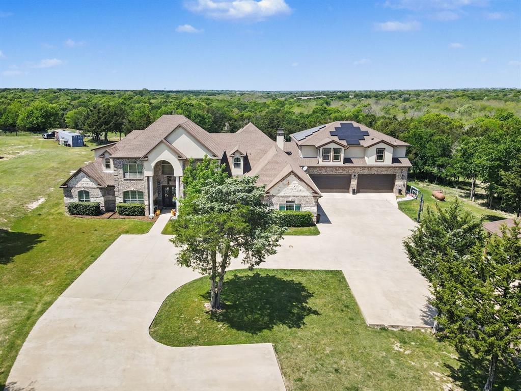 Welcome to an extraordinary estate set on 11.9 acres offering a resort style living just 17 minutes from Dallas, Texas. Designed for those who want it all, this property delivers unmatched space, luxury, and the ultimate setting for entertaining. From the moment you arrive, the scale is undeniable. Inside, the main level features three expansive living areas, each anchored by its own fireplace, creating multiple spaces to gather and relax. A dedicated office adds functionality, while the main-level primary suite offers a private retreat with an oversized spa-style bath and an expansive closet. At the heart of the home, a professional grade chef’s kitchen is built to impress, complemented by a separate guest quarters complete with its own bedroom, bathroom, kitchen, and living area, perfect for extended stays or multi-generational living. Outside, experience true resort living, an in-ground fenced pool, a covered heated patio with outdoor kitchen and seating, and an upper-level covered balcony overlooking your private acreage. Solar panels add efficiency to this already exceptional property. Ideally located near I-35E and I-20. Enjoy convenient access to shopping, dining, entertainment, and parks in Lancaster, DeSoto, and surrounding areas. This is more than a home, it’s a private retreat built for entertaining, relaxing, and living at a higher level. Opportunities like this are rare! Schedule your private tour and experience it before it’s gone. Discounted rate options and no lender fee future refinancing may be available for qualified buyers of this home. Some images are Virtually Staged
