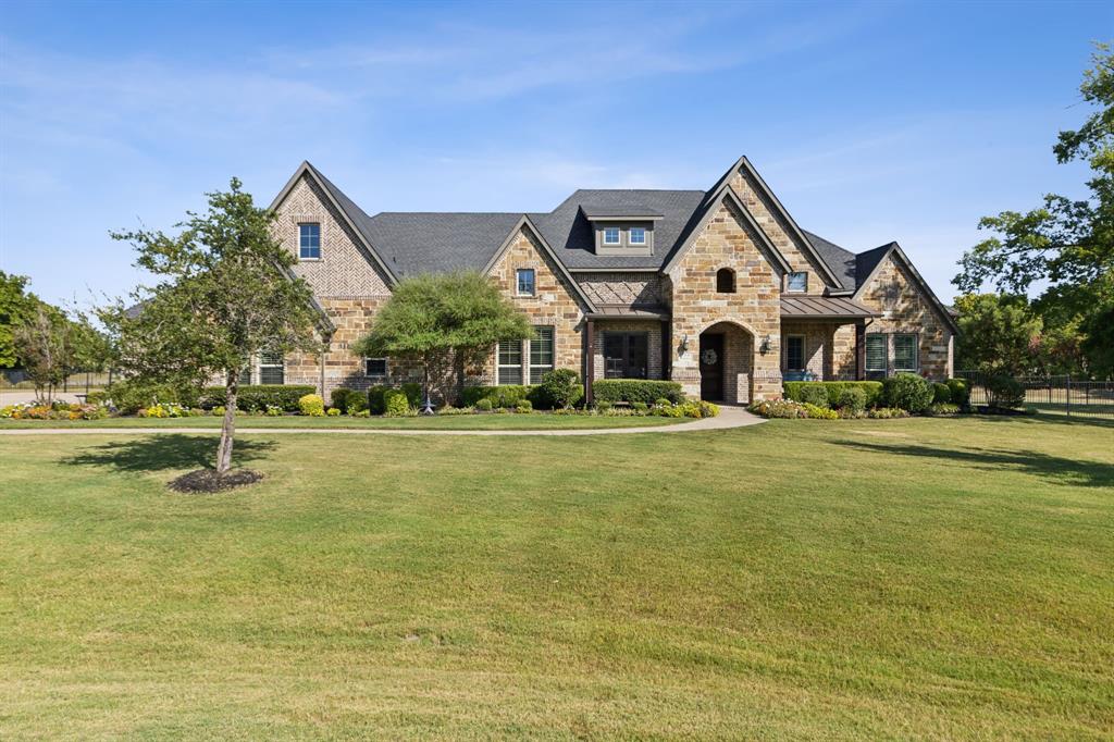 Tucked away at the end of a private cul-de-sac, this stunning estate sits on a premium 2.89-acre lot in the highly sought-after Lovejoy ISD. Designed for both elegance and comfort, this home boasts rich hardwood floors, intricate groin and beamed ceilings, and designer lighting that elevates every space. Step inside to a light-filled sitting room and elegant dining area, while a private office with French doors and custom built-ins provides a quiet retreat. The open-concept kitchen and living area are built for entertaining, featuring a wet bar, gas range, double ovens, spacious island, and custom ShelfGenie organization in every drawer and cabinet. The primary suite is a true sanctuary, complete with a cozy fireplace and a spa-inspired bath featuring a walk-through shower. A private guest suite with an ensuite bath is tucked away in its own wing. Three additional bedrooms—each with their own ensuite bath—are situated in a separate wing alongside a generous living space, half bath, and media room. A wall of sliding glass doors in the living room opens to an expansive covered patio with electric screens, seamlessly blending indoor and outdoor living. The resort-style pool and spa overlook sprawling green space, creating a tranquil backyard retreat. Primarily a one-story layout, the home also features a versatile upstairs bonus room—ideal for a gym, game room, or additional office. For automotive enthusiasts, the 5-car garage and 3-car parking pad provide ample space. Brand new roof to be installed soon - huge bonus for the buyers! This exceptional home offers the best of luxury, privacy, and space—plus sellers eager to welcome the next owners!