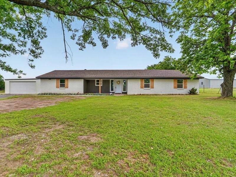 STUNNING ranch-style home completely remodeled situated on 3 beautiful acres, offering the perfect blend of modern luxury and country living. This spacious open-concept design features 4 bedrooms, including 2 primary suites, 3 full baths, and a 2-car garage. The designer kitchen is a showstopper with stainless steel appliances, a large island, quartz countertops, abundant prep space, and stylish lighting that carries throughout the home. The living area is anchored by a sleek modern fireplace with a gorgeous white oak mantle, creating a warm yet sophisticated focal point. Thoughtfully selected designer tile and upscale finishes in the kitchen and bathrooms add to the home’s custom feel. The oversized laundry room offers exceptional functionality with built-in cabinetry, extra storage, and a utility sink. Spacious secondary bedrooms are privately split from the main primary suite for added comfort and flexibility. Step outside to enjoy peaceful sunset views from the covered back patio overlooking the acreage. The property is fully equipped for those seeking a small farm or agricultural lifestyle with a barn, chicken coop, and two loafing sheds already in place. Enjoy quiet country living while still being conveniently located near schools, shopping, and everyday amenities. Welcome home!!