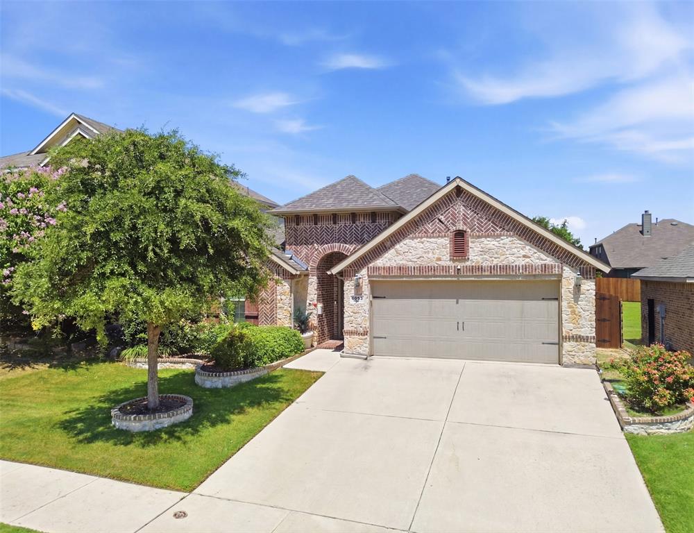 Former model home loaded with premium upgrades and exceptional attention to detail! This beautifully maintained, one-owner home showcases rich wood flooring throughout, an upgraded glass front door, and thoughtful landscaping that creates outstanding curb appeal. The open-concept split-bedroom floor plan is filled with natural light from expansive windows that overlook the beautifully landscaped backyard and spacious covered patio. Designed for both everyday living and entertaining, the outdoor space features a fully equipped outdoor kitchen, making it the perfect place to gather year-round. Inside, the kitchen and living areas offer upgraded cabinetry with glass accents, abundant storage, and timeless finishes. The spacious living room flows seamlessly into the generous dining area, creating an ideal layout for both everyday living and entertaining. The private primary suite is spacious and serene, featuring large windows, dual vanities, a separate walk-in shower, and an oversized walk-in closet. The secondary bedrooms are generously sized, providing comfort and flexibility for family, guests, or a home office. Located in the highly sought-after Eagle Mountain-Saginaw ISD, this exceptional home offers the perfect combination of quality craftsmanship, designer upgrades, functional living space, and an unbeatable location. This former model home truly has it all!