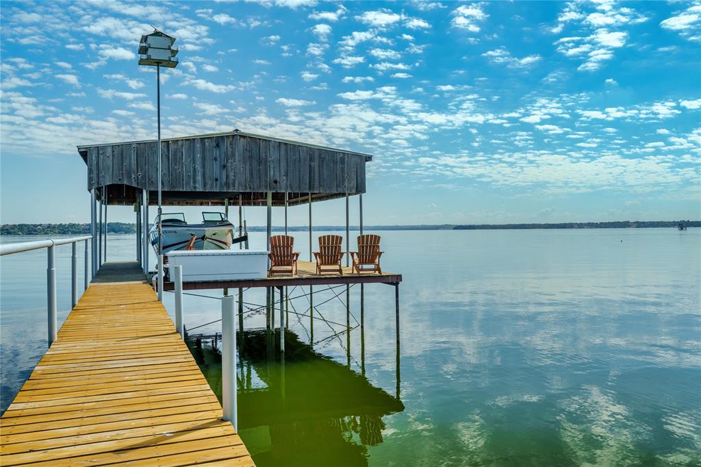 Million Dollar View Also available 1 + acre next door 216 N Broadway

Wake up to sparkling water views and a front-row seat to unforgettable sunrises at your own slice of paradise on highly sought-after Broadway Road on Eagle Mountain Lake. With 90 feet of open water frontage, this is where lake life slows down—in the best possible way.

Pull through the gated entrance and circle around the stunning, towering oak that anchors the drive, instantly setting the tone for the relaxed, private retreat that awaits. Inside, you’ll find three bedrooms, three full baths, and two spacious living areas designed for easy entertaining and making memories that last long after the weekend ends.

Pella windows throughout,  rich custom woodwork, and a blend of hardwood and travertine floors add warmth and character throughout.

Mornings begin with coffee on your private primary suite patio as the lake gently wakes up around you. Afternoons are for boating, fishing, or simply floating your cares away. And when the sun dips low, gather around the firepit, where laughter, stories, and starlit skies become part of your daily routine.

Need space for all the toys? The detached two-car garage and workshop are ready for lake toys, tools, and weekend projects.

Looking to expand your lakefront footprint? The lot next door at 216 N Broadway (MLS 2125447) is also available and would make a fantastic addition—offering an additional 100 feet of lake frontage and even more room to create your ultimate waterfront retreat.

Perfectly positioned just minutes from schools, shopping, dining, and everyday essentials, this home offers the rare combination of peaceful waterfront living with convenient access to everything you need.

Whether you’re looking for a full-time escape or the ultimate weekend getaway—this is lake life done right. Come experience it for yourself.

Buyer or buyer’s agent to verify all information, including measurements, schools