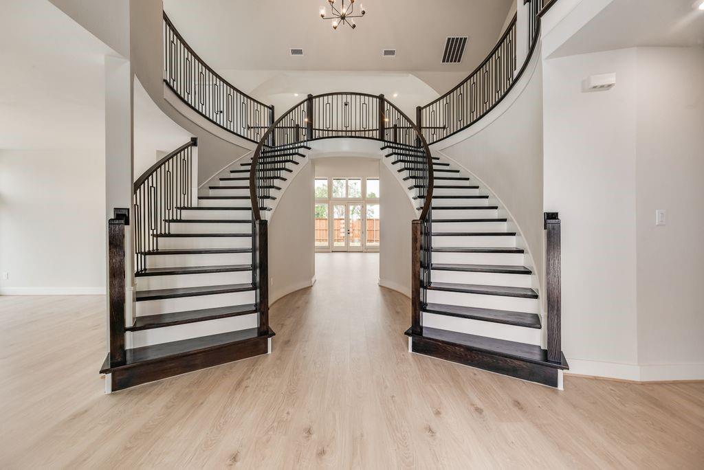 Newly completed Grand Home in Grand Estates of Anna with the rare advantage of No MUD and No PID taxes. Move-in ready and ideally located in one of North Texas’ fastest-growing communities, this stunning home offers the perfect blend of small-town charm, excellent schools, and convenient access to McKinney, shopping, dining, and major commuting corridors.
Nestled in a quiet neighborhood, this spacious open-concept design features 5 bedrooms, 4 living areas, and exceptional architectural detail throughout. Impressive drive-up appeal showcases a light brick and stone elevation with double front doors opening to a dramatic curved oak double staircase. Extensive wood flooring, soaring ceilings, and 8-foot interior doors create an upscale feel throughout the first floor.
Formal living and dining spaces provide the perfect setting for entertaining, while the vaulted family room features a sleek linear fireplace with stone surround and views of the covered back patio. Upstairs, enjoy a spacious gameroom and media room ideal for family movie nights or a private children’s retreat.
The chef’s kitchen is beautifully appointed with two-tone Shaker cabinetry, slab countertops, a 5-burner gas cooktop with custom vent hood, oversized island with pendant lighting, full bowl sink, trash drawer, walk-in pantry, and Butler’s Pantry opening to the formal dining room.
The luxurious primary suite offers a spa-inspired bath complete with a freestanding tub, oversized shower with dual shower heads, and separate vanities. A downstairs guest suite provides flexibility for visitors or a private home office. The oversized utility room offers abundant space for busy households.
Energy-efficient construction includes R38 insulation, radiant barrier roof decking, and durable 2x6 wall construction designed for comfort and lower utility costs. Enjoy the lifestyle and continued growth of Anna, TX — a thriving community known for its family-friendly atmosphere and strong sense of community.