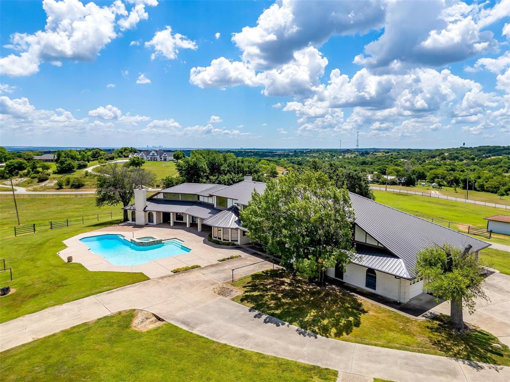 Rare Opportunity to Own a Piece of Coveted Aledo Real Estate! Sitting on 8 breathtaking hilltop acres w panoramic views across Parker County, this extraordinary 6,700sqft brick ranch house embodies elegance & charm. The home features walls of windows, ensuring every room captures the stunning scenery. The grand living room boasts a massive stone fireplace & vaulted coffered ceilings. Large eat-in kitchen w wonderful cabinets & double islands. The home also includes an exceptional study-lounge w handsome wet bar. Expansive primary ste w wet bar & fireplace. The spa & pool area offer unobstructed views for miles. The property is adorned w gorgeous mature oaks & rolling pasture land. Impeccable pipe fencing. Bring your horses & build your dream barn.  Located only 17 miles from Will Rogers Coliseum & 38 miles to DFW Airport. Ready for your design inspiration!