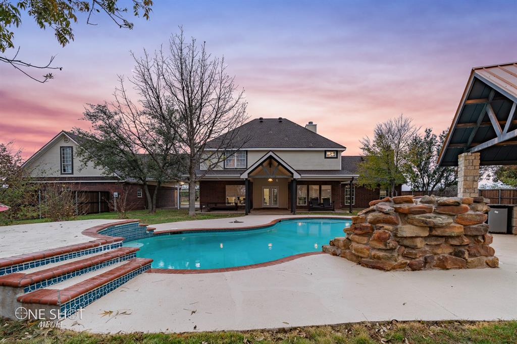 This exquisite property is on over 7 fenced acres, 4 bed, 3 bath home, a guest home with a kitchen and full bath, pool, outdoor kitchen, 900 sq ft workshop, 2 car carport, and 4 car garage. The heart of this home is its updated kitchen and expansive living area with fireplace. It's the ideal space for hosting both gatherings. The primary bedroom and ensuite has a fireplace, dual vanities, separate garden tub and shower, private toilet room and a walk in closet. The pool, adorned with a rock waterfall, serves as the centerpiece of the outdoor space anchored by an outdoor kitchen pavilion with fireplace and large covered porch, providing a serene retreat for relaxation and entertainment. A dedicated workshop caters to hobbyists and craftsmen. This versatile space can be tailored to various needs, from woodworking to artistry, providing a place for creativity and productivity. If you are looking for a home away from the city, but just close enough, put this one on your tour list today.