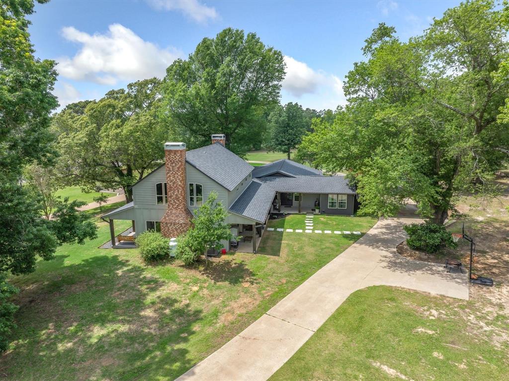 MOTIVATED SELLERS! Completely remodeled hilltop home in Canton ISD. This remarkable estate offers two updated homes, over eight and a half acres of land, and a detached garage with an efficiency apartment. The property welcomes you in with mature trees that frame the landscape and provide ample shade for the home. The main home showcases boutique finishes with complete remodel in 2023.Oversized Gas stove anchors the beautifully designed kitchen, complete with island made for family mornings together. Living area features a striking floor-to-ceiling wood-burning fireplace, and additional loft area provides additional space for gatherings or a secondary workspace. An office with outdoor access adjoins the primary bedroom, and the expansive front and back porches invite relaxation and enjoyment of the Texas weather throughout the day. The concrete driveway encircling the main home ensures easy access and ample parking. The secondary home includes two bedrooms, two bathrooms, and a two-car garage. Currently rented, this residence offers excellent potential for income or multi-generational living. Adjacent to the second home is a detached garage with an efficiency apartment, adding even more versatility to the property. The property is deed restricted to exclude mobile or tiny homes, preserving its charm and value. Pond on the property adds to the overall enjoyment. Conveniently located on FM 2909 within Canton ISD, this estate combines country living with proximity to restaurants, shopping, and local amenities. The setting, space, and thoughtful design make this property a rare find in East Texas.