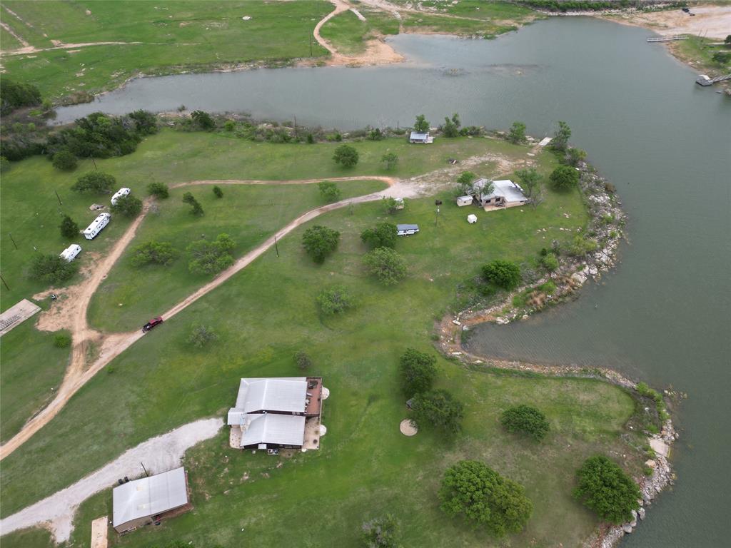 Are you looking for a strong investment opportunity with real cash-flow potential on Lake Leon in Eastland?
This seven-acre waterfront property is already set up and operating with RV hookups, offering immediate income potential. The property features a three-bedroom, two-bath mobile home in solid condition that could shine with a little TLC.
What truly sets this property apart is the expansive lake frontage, complete with a private boat ramp—making it ideal for both short-term and long-term rental use. Previously operated as a successful campground and restaurant, the groundwork is already in place for someone to step in and revive or reimagine the business.
Buyers should note that the property is a leasehold estate, with approximately 37 years remaining on the current lease, after which ownership reverts to the underlying owner. However, there may be an opportunity to acquire the underlying interest with a strong offer. The annual lease payment is just 300 dollars, paid to the water department.