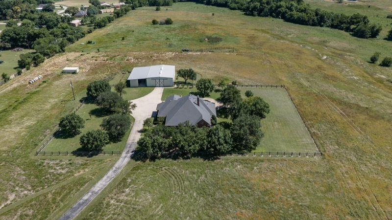 This 3,702 sq ft exceptional home with many extras located on 41.3 beautiful acres with highway frontage is adjacent to Decatur city limits. While having multiple capabilities of being everything from the perfect horse property which it is already set up to be, it can also be an amazing residential development as well as it’s perfect to build an office business park with plenty of level tracts on highway frontage. The acreage is beautiful with numerous pecan, oak and other trees along a small creek at the back of the property. The 4-bedroom, 4 bath home has crown molding throughout, a study with built in cabinets, a breakfast area with built in China cabinet, a primary suite and a second suite downstairs with 2 bedrooms or 1 bedroom and a second family room and bath upstairs. The property is beautifully landscaped with asphalt driveway. It also, has a large pool with the plumbing for the installation of an outdoor kitchen to easily be built for any outdoor entertaining you should desire. There is Coop water and a water well for the house as well as a second well for the barn and animals. The 1,800 sq ft horse barn and shed is equipped with 4 stalls and a tack room. Additionally, a 2,400 sq ft high roof, storage barn, shop, RV barn with 50 amp plug in adjoins it. Many other amenities including a fenced in garden area for whatever you want to grow. YOU MUST SEE THIS TODAY!