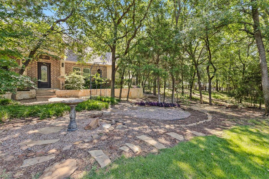 NOW OFFERED AT A NEW PRICE! 950 Garnet Cove in the Emerald Sound community of Oak Point, Texas offers a 3,328 square foot home with all bedrooms located on the main level, an upstairs media room, multiple living areas, and extensive updates throughout. Situated near Lake Lewisville in Denton County, this property combines a functional layout, renovated interior, and a heavily treed backyard designed for privacy and outdoor living.

The completely renovated kitchen serves as the centerpiece of the home and features custom cabinetry with built-ins, a large island, breakfast bar, eat-in dining area, upgraded backsplash, pot filler, and a 6-burner gas range. The adjacent living room is filled with natural light and provides an open flow for everyday living and entertaining.

The main level includes all bedrooms, a spacious primary suite with a massive walk-in closet, a second living area, and a flex space previously used as a home gym that can serve as an office, studio, or additional living area. An upstairs media room provides additional separation and versatility. Interior improvements include all new interior paint, plantation shutters, upgraded lighting, and two fireplaces.

The outdoor living spaces include updated front and back porches and a redesigned patio overlooking one of the most private backyards in the neighborhood. Mature trees surround the property, creating substantial privacy and a natural setting. A large detached storage building offers flexible use for storage, workshop space, studio, or home office.

Located in Emerald Sound on Lake Lewisville, this Oak Point property offers convenient access to boating, outdoor recreation, major commuter routes, shopping, and dining throughout Denton County and the surrounding North Texas area.