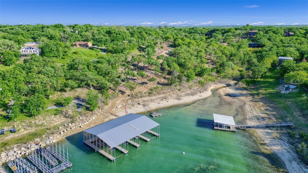 Looking for an affordable way to own true Lake Texoma waterfront? Lot 1A-1 is your opportunity. With 0.83 acres, this buildable lot includes one 50-ft private boat slip in a brand-new boathouse with full utilities. Ownership includes shared access to a beautifully placed waterfront parcel with easy golf cart path for access. Enjoy the lake lifestyle — fishing, boating, and nature — all with the security of deeded shoreline rights, no Corps land buffer, and utilities in place. This property is minutes from Eisenhower State Park and the highly anticipated Margaritaville!