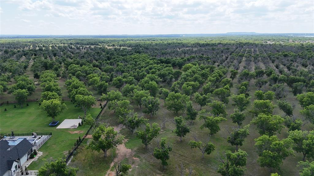 Build your dream home on this stunning 1.1-acre homesite located in the highly desirable Landings at Pecan Plantation in Granbury, Texas. Nestled among beautiful mature pecan trees and surrounded by custom-built homes, this property offers the perfect combination of luxury living, privacy, and peaceful country atmosphere while still being conveniently located near city amenities. With plenty of room to design your ideal home, workshop, pool, outdoor entertaining area, or additional landscaping, the possibilities for this property are endless.

Located inside the gated and guarded community of Pecan Plantation, residents enjoy access to an incredible list of resort-style amenities including multiple golf courses, country club access, community swimming pools, parks, tennis courts, pickleball courts, walking and biking trails, marina and boat ramp access on the Brazos River, fishing areas, equestrian facilities, playgrounds, and on-site dining options. The community also features a private airpark, grocery store, pharmacy, medical offices, banking, and other conveniences all within the neighborhood.

This property offers paved road frontage, available utilities, and a prime location within one of Granbury’s most sought-after communities. Enjoy the peaceful surroundings of nature and wildlife while being only minutes from the Historic Granbury Square, shopping, dining, entertainment, and highly rated schools. Convenient access to Fort Worth makes this an excellent option for a full-time residence, retirement home, or weekend getaway property.

Whether you are ready to build now or looking to invest in one of Granbury’s premier communities, this rare 1.1-acre lot presents an outstanding opportunity to own a piece of the Texas lifestyle in beautiful Pecan Plantation.
