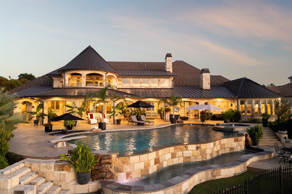 Discover unparalleled lakefront living in this stunning estate perfectly positioned on the shores of Lake Ray Hubbard. Set on over an acre of beautifully manicured grounds, this 10,000-sq-ft home blends timeless architecture with exceptional amenities. A grand entry welcomes you into expansive living spaces framed by floor-to-ceiling windows that showcase breath taking views of the water. The gourmet kitchen, elegant formal areas, and richly designed home office create an ideal environment for both refined entertaining and everyday comfort. Primary bathroom host a walk in shower with massage jets. Large his and hers custom closets with tons of storage and practical usage. Outside, resort-style living awaits with an infinity-edge pool, spa, fire pit, and a private dock with boat slip and lift — offering effortless access to the lake. The lake yard also boast a beautiful riverbed that flows into the lake and uses recycled lake water to create a sense of ambiance and tranquility. Tucked behind a gated entrance on a quiet cul-de-sac, this property delivers unmatched privacy, luxury, and the ultimate waterfront lifestyle. This property is truly one of a kind.