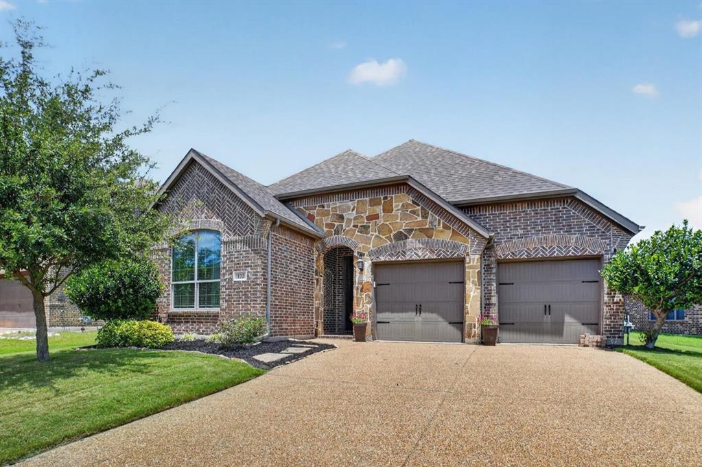 Welcome home to this beautifully maintained brick and stone traditional in the established Williamsburg community of Fate! Light-filled and inviting, this 1,844-square-foot home features an open floorplan anchored by a spacious living room with coffered ceilings and a cozy gas log fireplace. The eat-in kitchen is a true centerpiece, offering granite counters, a large center island with breakfast bar seating, abundant warm-toned cabinetry, stainless steel appliances, and a walk-in pantry. A charming bay-windowed breakfast nook overlooks the backyard, while decorative lighting and ceramic tile flooring add character throughout the main living spaces. The serene primary suite features bay windows, a dual-vanity bath with garden tub, separate shower, and walk-in closet. Outside, enjoy a covered front porch, covered rear patio, private wood-fenced yard, and full sprinkler system — perfect for relaxing or entertaining. The two-car garage offers an oversized 20x24 footprint with extra room for storage. Williamsburg residents enjoy resort-style amenities including a community pool, clubhouse, playground, lake, and jogging and bike paths, all within sought-after Rockwall ISD. Conveniently located near I-30 with easy access to Rockwall shopping, dining, and Lake Ray Hubbard. Don't miss this one — schedule your showing today!