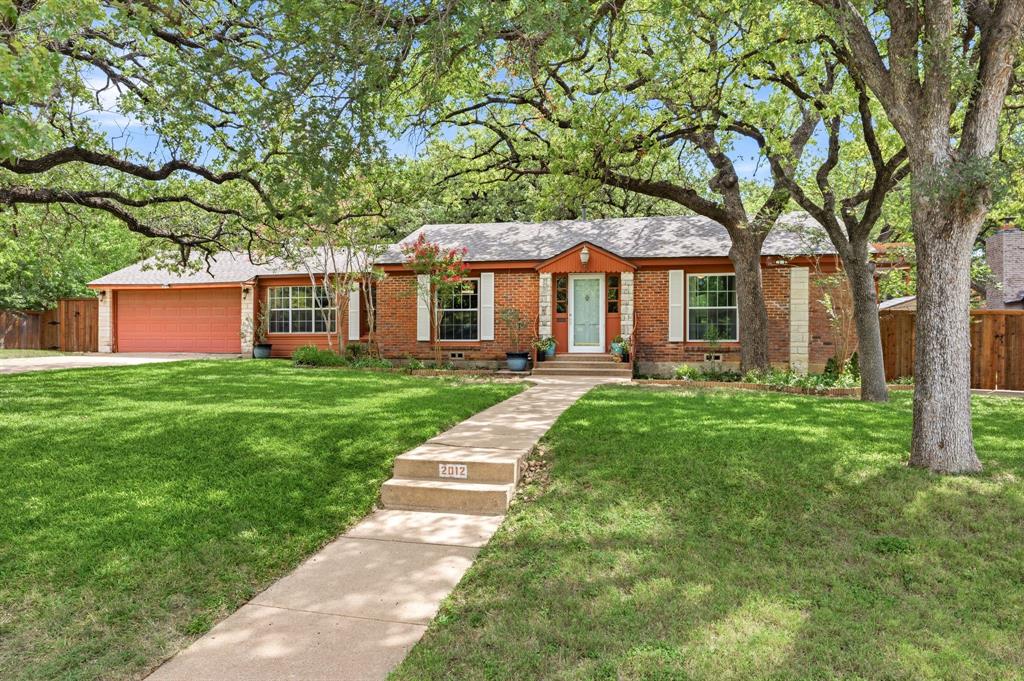 Timeless 1948 ranch-style home situated on an oversized lot-and-a-half in Fort Worth’s beloved neighborhood of Oakhurst. Unique outdoor features include an enormous backyard with wood privacy fence, mature landscaping, storage shed, 11 x 56 RV, boat, or extra vehicle parking area, and multiple covered entertaining spaces. Inside, vintage character blends seamlessly with thoughtful modern updates. Note original millwork, oak hardwood floors, stained-glass accent windows, custom antique furniture-vanity, penny-tile sunroom flooring, and period-inspired lighting throughout. The kitchen is a standout centerpiece, designed and enjoyed by a professional chef. Highlights are vaulted beadboard ceilings, concrete and butcher block countertops, 48-inch commercial-grade gas convection range with 6 burners plus grill and exterior ventilation, counter-height breakfast island, butler's cabinet with beverage fridge, ledgestone backsplash, and stainless-steel appliances. A pet door and abundant garage, built-in, and closet storage enhance the home's functionality without sacrificing charm. In addition to two massive bedrooms and an open family-living space, there are four versatile flex areas currently used as a dining room, breakfast area, office-den, and sunroom. These adaptable spaces can easily serve as a library, fitness room, hobby nook, guest quarters, or additional living areas. Major system updates include windows, ceiling fans, tankless water heater, compressor, paint, and June 2026 roof. Oakhurst itself is known for picturesque rolling hills, mature trees, skyline views, neighborhood park, and convenient access to Trinity Trails, Downtown, Stockyards, Panther Island, and major thoroughfares. The award-winning neighborhood is listed in the National Register of Historic Places, however there are no strict city preservation requirements. Best yet, there is no mandatory HOA, rather a voluntary neighborhood association focused on community, beautification, and preservation.