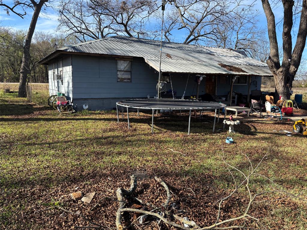 House with 5.6 acres at the corner of Hwy 11 and FM 1553.  Come take a look and then take advantage of this opportunity.  The property has many mature pecan trees and has  Burr Oak creek as it's North border.  There is a perimeter fence that will hold animals with minimal work. There is also a loafing shed to shelter any stock you may have. The home needs some TLC and updating but has good bones. No restrictions. Property is located in a flood zone.