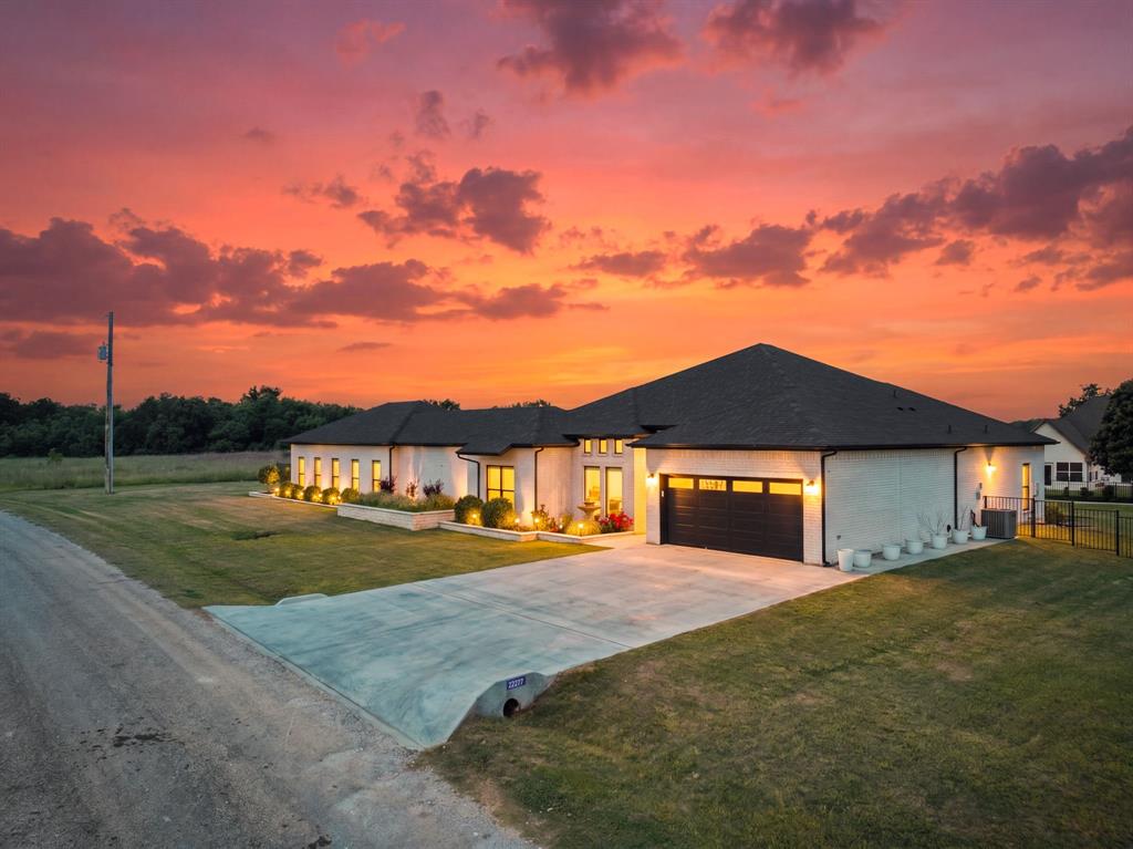 Experience luxury lake living at its finest in this stunning, like-new home that makes a bold statement within a premier gated resort community. Set on over half an acre, this beautifully maintained property offers modern architecture with contemporary design elements creating a presence that is both timeless and refined. The thoughtfully designed open floor plan features warm, neutral tones and modern finishes throughout, creating an inviting and sophisticated atmosphere. Extra-large island offers separation and allows visiting with family and friends with seating at the island.  detailed with high-quality finishes. The spacious primary suite is a true retreat, complete with a large walk-in closet and a beautifully appointed en-suite bath featuring a tiled shower with a sleek glass door. Step outside to your private backyard oasis, where lush green grass, meticulous landscaping, and elegant iron fencing frame an expansive patio ideal for entertaining. A charming pergola provides shade and ambiance, while the unique basketball court offers versatility—its removable tile system reveals a large slab beneath, perfect for multiple uses. The property also includes a detached guest quarters with a full bath and private entrance, offering comfort and privacy for visitors. In addition to the attached two-car garage, a separate garage workshop with a roll-up door provides extra space for your golf cart, tools, or lake toys. Located just moments from the golf course, this home is part of an exclusive, amenity-rich community featuring a marina, multiple pools, dining options, and abundant recreational opportunities. Spend a day at the lake and enjoy the serenity of nature with thousands of acres of roaming wildlife, all within the security of a guarded entrance.  Join a true community lifestyle where luxury and leisure exist in perfect harmony.