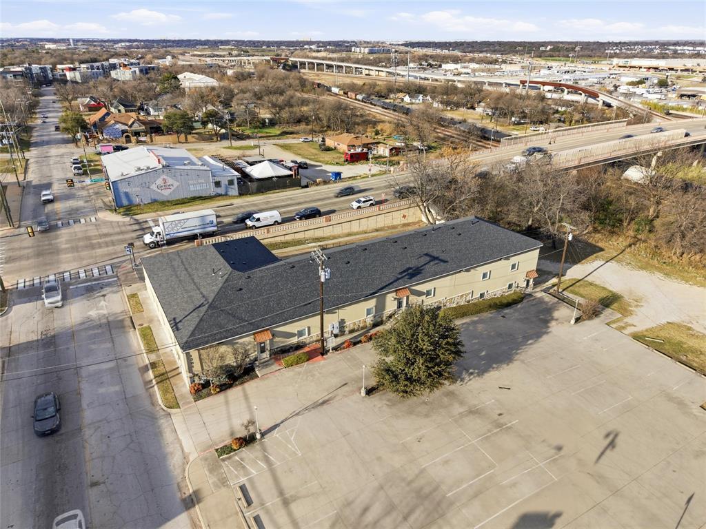 This newly remodeled commercial building is ideally located in downtown Fort Worth and offers a flexible, professional environment well-suited for a wide range of office and service users. Thoughtfully renovated with modern finishes and updated systems throughout, the property blends contemporary functionality with established character. The building is designed as two separate suites, each featuring its own reception area, private offices, and dedicated conference and collaboration spaces. Both levels function as ground level due to the natural slope of the lot, providing convenient access from multiple sides of the property. Ceiling heights reach an impressive 12 feet on the upper level and 10 feet on the lower level, enhancing the open, modern feel across the space. The west suite includes a well-appointed conference room with a built-in mini refrigerator, along with a full kitchen equipped with a range and microwave with exterior exhaust venting. This suite offers eight private offices, a mail room, and a dedicated server room—an ideal configuration for professional, legal, or technology-focused users seeking both client-facing and operational areas. The east suite features nine private offices and a large open room on both levels, complemented by a server closet and exposed ductwork that highlights a contemporary, industrial-inspired aesthetic. The flexible layout makes it especially appealing for creative firms, engineering groups, or collaborative teams. With its prime downtown location, efficient and versatile floor plan, multiple points of access, and a balanced mix of private and open workspace, this remodeled property presents an exceptional opportunity for owner-users, multi-tenant occupancy, or investors seeking a presence in one of Fort Worth’s most active commercial corridors.