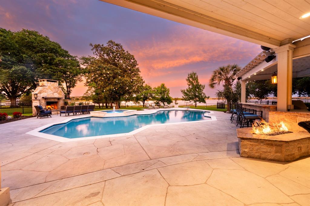 Welcome to 4206 Shadybrook Lane, this stunning home is nestled between large shade tree's on a cul de sac in the small quiet gated neighborhood of Pecan Harbor. Beyond the etched glass front door you are greeted by an elegant staircase flanked by a study and dining room, both with custom built in's. Once in the heart of the home, the gourmet kitchen you will find an entertainers dream space. Stainless steel double ovens, a professional 6 burner gas cook top with griddle, 3 dishwashers, ice maker, 2 islands, 2 trash pull outs and a walk in pantry all open to the 2 story family room with broad sweeping views of the resort style back yard pool and lake. The master suite is a wing of it's own featuring a sitting area, en suite bath with round soaking tub, dual vanities, stunning shower and a custom designed walk in closet with it's own washer and dryer. Upstairs the breath taking views continue with 4 additional bedrooms, 2 with en suite baths, laundry room, sitting area with balcony access and a huge game room with views of the pool and lake. The third floor is dedicated to a private media room. Shutters, automated roller shades and lighting, dual stair cases, 3 gas log fireplaces, glassed in wine storage, lake pump for lawn irrigation, and a Tesla charger are just some of the other features of this home. Outside you will find a private oasis. Covered patio with built in grill and bar, heated pool and spa, gas fire pit, and wood burning fireplace with chimney for all the outdoor entertaining you can imagine. Boat dock has boat lift and 2 jet ski lifts. The owners have carefully and thoughtfully renovated this entire home. Once you tour this amazing property will see why homes in this neighborhood do not come on the market often, this is a rare opportunity!