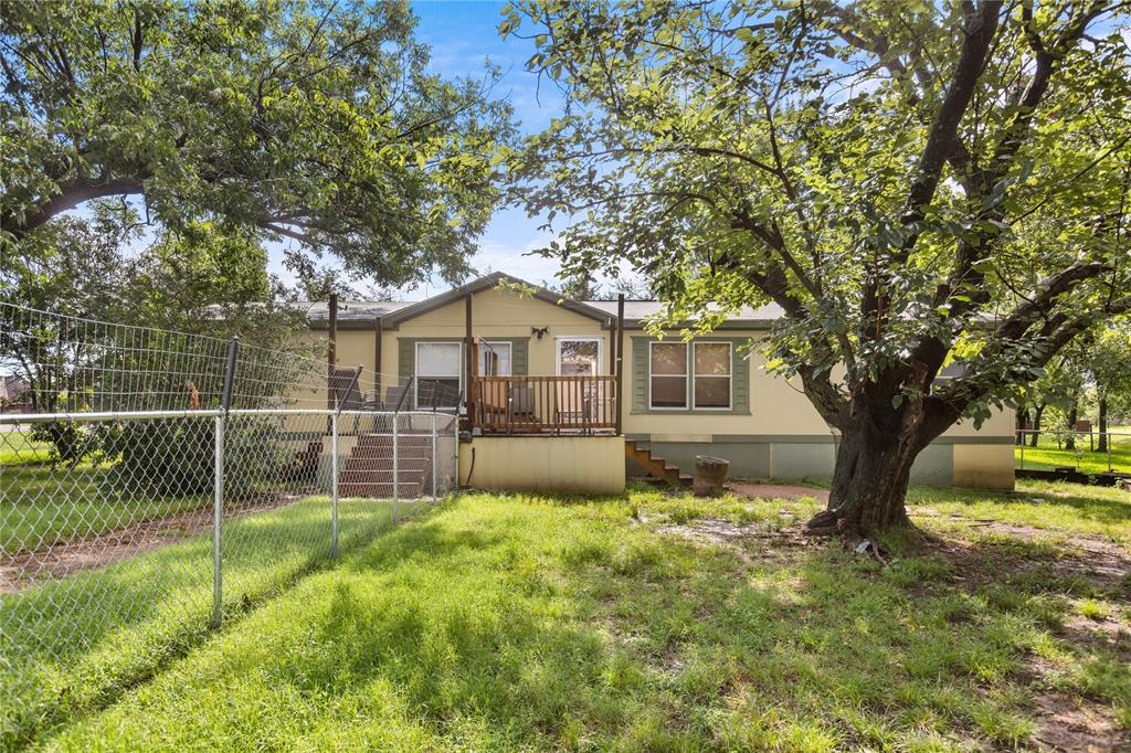 Looking for space both inside and out with easy access to one of North Texas' most popular lakes? This charming manufactured home sits on over an acre and is located approximately 5 minutes from Lake Texoma, making it an excellent option for full-time living, a weekend retreat, or a place to store all your lake toys.

The home features 3 bedrooms plus a versatile bonus room with direct access from the primary suite. This additional space would make an ideal nursery, home office, sitting room, craft room, or hobby space.  For added stability and peace of mind, the home is anchored to a concrete slab foundation.

Outside, you'll find one of the property's most impressive features—a 1,500-square-foot workshop complete with electricity and three garage bays. Whether you need space for vehicles, boats, tools, equipment, or projects, this shop offers endless possibilities.

The property is enhanced by beautiful St. Augustine grass, mature shade trees, and a chain-link fenced area perfect for pets or outdoor enjoyment. A drainage ditch has been installed to help manage water flow and reduce standing water concerns, allowing you to enjoy the spacious yard year-round.

Properties offering this much space, functionality, and proximity to Lake Texoma don't come along often. Bring your boat, your hobbies, and your vision for making this property your own.