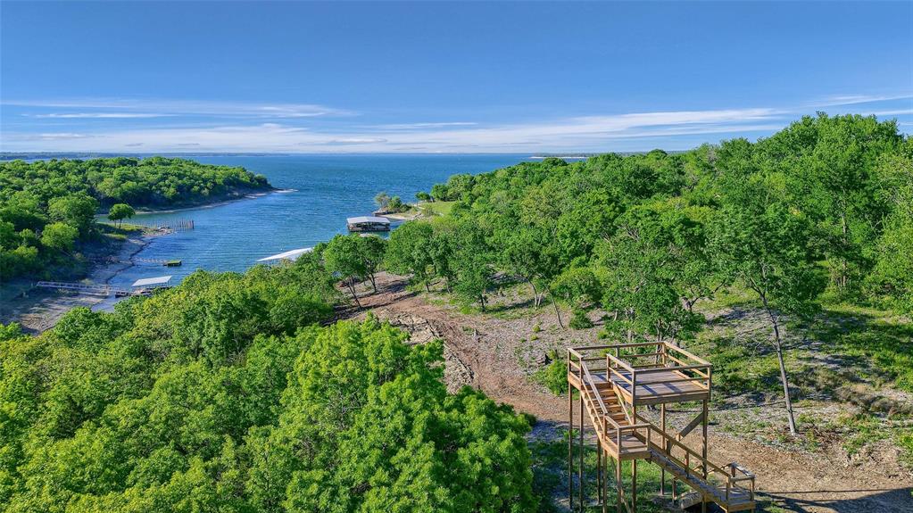 This 1.29-acre lot in Thompson Heights blends elevation, privacy, and panoramic lake views with deeded access to a premier 4-slip boathouse. Enjoy one 50-ft boat slip, complete with water and power, in a protected cove just seconds away via a shared waterfront parcel. The lot is ready for your custom dream home, with mature trees, flexible topography, and nearby utilities. Don’t miss the chance to build in one of Lake Texoma’s most exclusive lakefront enclaves. Just minutes from the highly anticipated Margaritaville!
Highlights:
1.29 Acres
1 Deeded Boat Slip
Elevated Building Site
Tree-Covered for Natural Privacy
Shared Access to Waterfront & Boathouse
Paved Access + Utilities