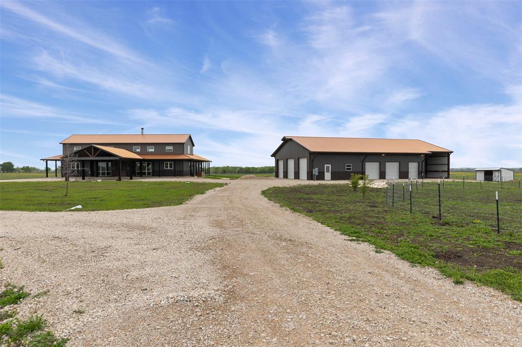 Situated on approximately 50± acres in Ellis County, TX, the Waxahachie Estate offers the perfect balance of privacy and convenience, providing a peaceful rural escape just minutes from the metroplex. Beyond the gated entrance, a scenic driveway winds through the property, leading to a beautifully designed 4,000 sqft home and a spacious 3,100 sqft shop. The property’s meticulously maintained coastal pastures create a breathtaking backdrop, enhancing its serene and picturesque appeal. Thoughtfully designed and impeccably cared for, the Waxahachie Estate presents endless possibilities to bring your vision to life.

House:
This stunning house, built in 2020, boasts a generous 4,000 square feet of modern living space, thoughtfully designed for both comfort and style. With three spacious bedrooms and three and a half baths conveniently located on the main floor, it offers an ideal layout for families or entertaining guests. Large windows flood the open-concept living area with natural light, highlighting the sleek finishes and contemporary architecture. The gourmet kitchen features state-of-the-art appliances and ample counter space, making it a chef's dream. Adding to its charm is a beautifully designed wrap-around porch that not only enhances the home's curb appeal but also increases the total square footage to an impressive 5,100. The foundation of the house is an Eyncon concrete slab, engineered to be guaranteed for life, with the warranty transferring over to the new owners. This inviting outdoor space serves as a perfect backdrop for relaxation and gatherings, making this home a true oasis.

Shop:
This spacious 3,100 square foot shop is a versatile haven for both work and leisure. Designed with functionality in mind, it features a fully equipped gym, allowing for convenient workouts without leaving the premises.