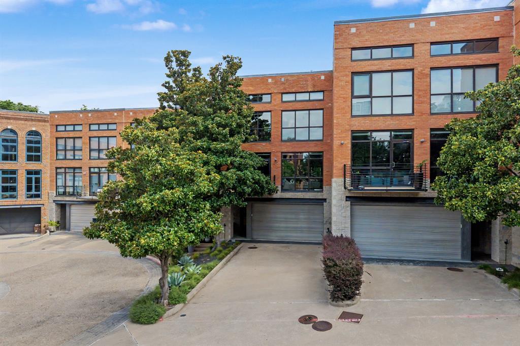 Set within an intimate gated community in the heart of Victory Park, this striking contemporary townhome seamlessly blends sophisticated design, exceptional outdoor living, and lock-and-leave convenience. The light-filled open floorplan features soaring ceilings, walls of glass, and stunning views of both the surrounding cityscape and mature magnolia trees. Designed with entertaining in mind, the recently remodeled custom Christopher Peacock kitchen is complemented by a stylish bar with beverage refrigerator and flows effortlessly into the living and dining spaces. Automated screens, an integrated sound system, and Lutron lighting throughout provide both comfort and convenience. The first-floor guest suite offers a private retreat complete with a beautifully appointed bath featuring Ann Sacks tile, Christopher Peacock cabinetry, and direct access to a private outdoor patio. Upstairs, the expansive primary suite serves as a true owner's retreat, complete with a separate sitting area ideal for a home office, fitness space, or private lounge. Outdoor living is a standout feature, with multiple private terraces and a dramatic two-story entertaining area anchored by a stone fireplace, creating a rare urban oasis perfect for relaxing or hosting guests. Residents enjoy access to the community pool, connectivity to the Katy Trail, and walkability to the American Airlines Center, the new Goldman Sachs campus, premier dining, shopping, and entertainment. This is a rare opportunity to enjoy luxury, privacy, and an unparalleled urban lifestyle in one of Dallas' most vibrant neighborhoods.