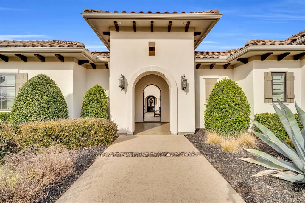 Exquisite single-level estate nestled inside the private, gated enclave of Chateau Du Lac’s most exclusive section, The Enclave. This custom-built residence offers a rare luxury living, designed with an open-seamless layout that blends sophistication and comfort. From the moment you arrive, the home impresses with its elegant courtyard entry featuring a cozy fireplace, a perfect setting for entertaining! The chef’s kitchen is both striking and functional, anchored by a 6-burner gas range, built-in refrigerator, oversized island, granite surfaces, and custom 42in cabinetry, ideal for entertaining on any scale. Every bedroom is a private en-suite, ensuring privacy for family and guests alike, while the owner’s retreat feels like a five-star spa with a soaking tub, frameless walk-in shower, dual granite vanities, and a custom-designed closet. A separate fifth bedroom with its own entrance offers an exceptional guest or in-law suite option, and the media room is pre-wired for 7.1 surround sound for an immersive experience. Outdoor living is equally impressive with multiple covered patios, an outdoor kitchen, and a spacious backyard that invites endless possibilities. High-end finishes throughout include hand-scraped hardwood floors, crown molding, 8’ solid-core doors, elegant baseboards, and a stunning cast-stone fireplace. Recent updates such as freshly painted stucco, recent driveway finish, and epoxy-coated garage floors. Energy-conscious features like a tankless water heater, radiant barrier roof decking, Low-E3 windows, a 16-SEER HVAC system, and a pre-wired security system provide peace of mind and efficiency. Professionally landscaped grounds framed by wrought iron fencing and accented by cedar garage doors complete this move-in ready estate. Truly a rare opportunity to own a luxury single-story home in one of Flower Mound’s most prestigious communities. Across the street the street from a catch-and-release pond for fishing enthusiast.