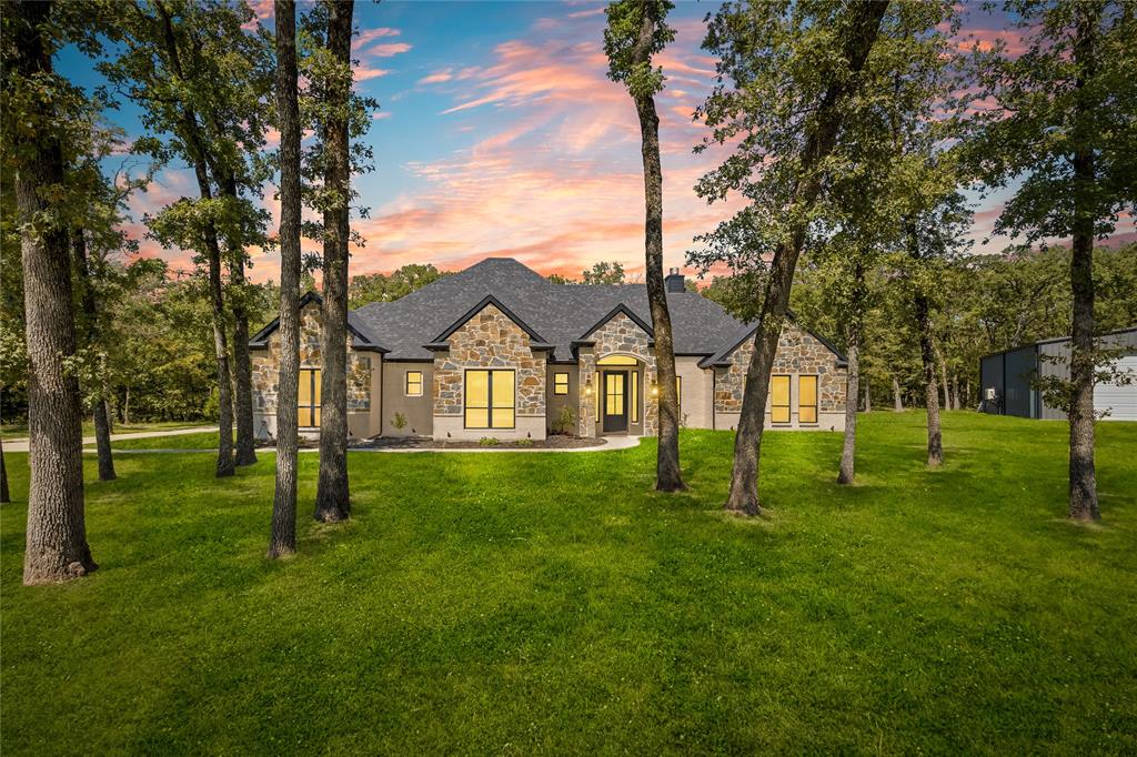 LAKEFRONT HAVEN + 2000sf SHOP nestled at the end of a quiet cul-de-sac in Nautical Shores, backing into 45 acres of privately owned land! This stunning 2023 Clements custom home sits on 2.15 acres with nearly an additional acre of SRA leaseback land. Perfectly positioned on the shores of Lake Tawakoni and adjoined by SRA-protected land, the property offers unobstructed views, rare privacy, and a front-row seat to the lake’s abundant wildlife.

Inside, you're welcomed by a dramatic living room with soaring ceilings, custom built-ins, and a striking stone wood-burning fireplace. The open-concept design flows seamlessly into a spacious dining area and a chef’s kitchen complete with pot filler, oversized island, top-of-the-line stainless steel appliances including fridge, double ovens, and a walk-in pantry. A small enclosed office space with desk is just off the hallway.

The thoughtful split-bedroom layout ensures comfort and privacy. The primary suite serves as a true retreat with a spa-like bath boasting an oversized walk-in shower with multiple shower heads and dual expansive walk-in closets. On the opposite side of the home, three additional bedrooms each with their own bathroom!

Outdoor living is equally impressive, with a wide covered patio featuring a ceiling fan and a 2nd wood-burning fireplace—the ideal setting for entertaining summer guests or enjoying crisp fall evenings by the lake.

Hobbyists will appreciate the 2,000 sqft shop, complete with electricity, AC, 3 insulated 14ft doors, a full bathroom, and a private office. Additional highlights include an upgraded septic system with dual 750-gallon tanks, and an engineered slab with 70+ piers 18ft deep, secured with post-tension cables. Plus convenient access to the neighborhood’s private boat launch. Furniture included with right offer!

Seeking even more space and opportunity? Adjacent 1ac parcel (plus 0.93 SRA acres) available NOW, enhancing privacy, space, and long-term value (MLS 20996018).