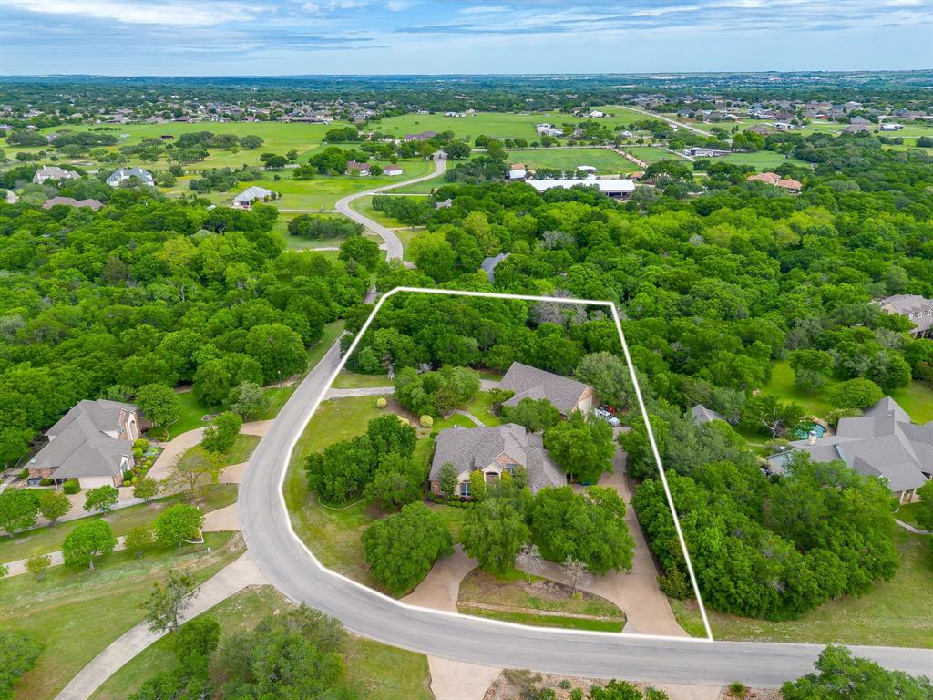 Gorgeous custom home in a gated neighborhood with an amazing workshop, all on 2 heavily treed acres.  Corner lot with a circle drive and a driveway that goes through the workshop which can be accessed by both sides of the street. Amazing finishes throughout with plantation shutters, crown molding, built-ins and much more. Formal dining of entry with access to the kitchen.  Large family room with a fireplace and built-ins with access to the kitchen with an island, an abundance of cabinets, and solid-surfaced countertops, open to large breakfast nook. Oversized primary suite with fireplace and ensuite with garden tub, separate shower, dual sinks, and wonderful closet for storage. Large utility room with built-ins and room for a fridge. Upstairs boasts a large second living room or game room with built-ins and 2 bedrooms with a jack-n-jill bathroom. Outdoors is a paradise with a large patio for entertaining, second patio with a built-in grill, fireplace and plenty of room for guests, and a third wood deck for entertaining. All overlooking the private space for wildlife. The workshop is a dream with one side for working or storage, a second side to park your RV or vehicles, and a full bathroom. 2 roll up doors to pull your vehicles in and use as a drive through to both sides of streets. A rare find in an amazing neighborhood and place to call HOME.