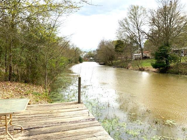Lakefront property features approximately 1.34 acres, aerobic septic, community water, electricity, storage container, covered area for parking or partying on a quiet paved road. Wow everything you need is here. The property has a rock driveway and pad site with RV hook ups, is cleared with scattered nice large oaks and other shade trees. A 40’ container with spray in insulation water & electric on the property. Container has washer & dryer hook ups and is a great storage facility for your mower, lawn tools, ATVs or make it a man cave. Approximately 28.5x32.5 covered area has a gravel base with water and electric and is a great place for parking a 2nd RV, vehicles, boats or a place to party and dine outdoors.