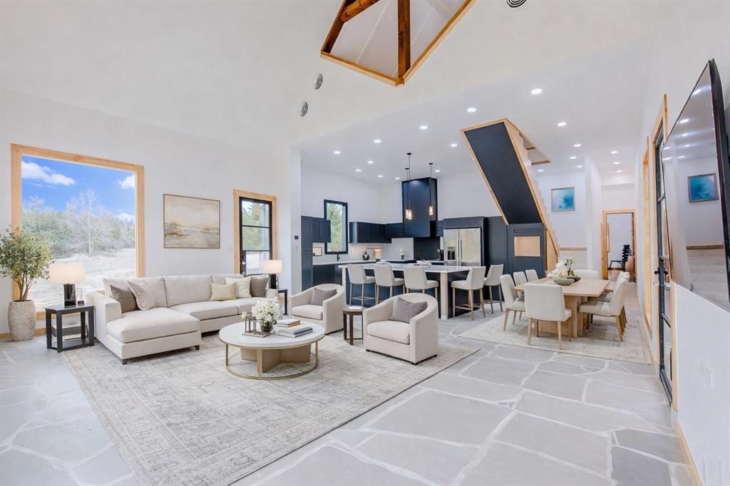 No neighbors in sight—just 17 breathtaking acres of mature trees, open space, a pond, seasonal creeks and walking trails surrounding a one-of-a-kind contemporary retreat. This custom 2,678-square-foot home is designed for buyers who want a true weekend escape or a peaceful full-time residence: absolute privacy, quiet, and stunning views from every single window.

Step into the main living and kitchen area where hand-cut natural limestone floors meet soaring 28-foot ceilings and dramatic custom 6×6 cedar beams. A striking wall of seven oversized 8’ × 4.5’ windows floods the home with natural light and frames uninterrupted vistas of your land—woods, water, and wide-open sky—so every glance feels like a lookout point.

Thoughtful craftsmanship continues throughout: natural Douglas fir window trim, JELD-WEN aluminum-clad architectural-series windows, foam insulation throughout and a primary suite finished with wall-to-wall white oak flooring and massive 8-foot solid wood doors. A custom hand-built maple staircase leads to an upper level with a spacious bedroom, full bath, and second living area, complemented by wall-to-wall natural red oak hardwoods.

Outside, the acreage invites whatever “relaxing living” means to you—quiet mornings on the patio, exploring private trails, hunting, or building the next phase: workshop, barn, carport, or a full outdoor retreat. Peacefully secluded, yet convenient to Highways 11 and 78, with everyday essentials about 15 minutes away and McKinney, Greenville, or Sherman within roughly 35 minutes.