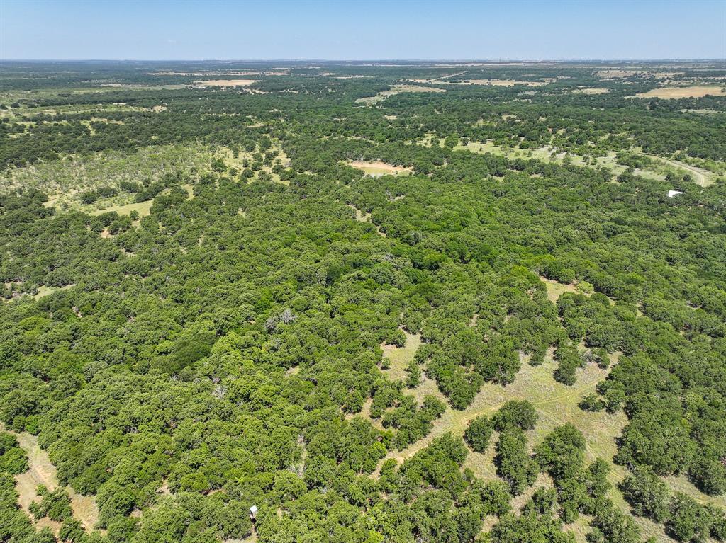 Welcome to this exceptional 70.15± acre high-fence ranch, a turnkey recreational property offering trophy whitetail hunting, privacy, and incredible natural beauty. Covered in mature post oaks with two creeks, dramatic elevation changes, and stunning views, this ranch provides a landscape rarely found in the area. Carefully managed for personal use, the ranch boasts an outstanding whitetail herd, with deer reportedly reaching the 180–190 inch class range. Additional wildlife includes turkey, dove, quail, and bobcat, creating a true year-round sportsman's paradise. Originally developed as a deer breeding operation, the property retains an extensive pen and watering system. The current owner keeps all gates open, allowing deer to roam freely while still benefiting from the established infrastructure. The hunting cabin features 1 bedroom, 1 bathroom, a loft with bunk beds, full kitchen, laundry room, spacious living area, and wood-burning fireplace, comfortably sleeping up to eight guests. A separate 1-bedroom, 1-bath guest suite provides additional accommodations. Water resources include two water wells and two stock tanks, including one year-round tank reaching approximately 14 feet deep when full. Additional improvements include two barns, one measuring 25x25 with concrete flooring and electricity. Deer blinds, feeders, and stands convey with the sale, making this a true turnkey opportunity for hunters, families, or investors seeking a unique ranch property. {Information believed accurate but not guaranteed. Property sold “as is.” Acreage, maps & fence lines are approximate. Buyers should verify details. Subject to errors, changes, prior sale, or withdrawal.}