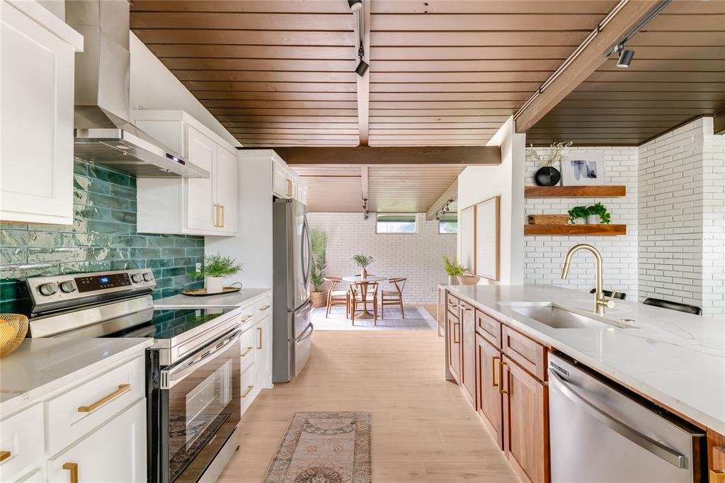 Welcome to this architecturally striking mid-century modern gem, completely reimagined with refined finishes, dramatic design, and today’s comforts in mind. Framed by mature trees, this home is an inspiring blend of clean lines, rich textures, and unexpected charm.

Inside, soaring ceilings, clerestory windows, and crisp natural light flood the open living spaces. A double-sided brick fireplace anchors the layout, effortlessly connecting the inviting living and dining areas. The kitchen is a showstopper—featuring a full suite of stainless steel appliances and a quartz-topped island with waterfall edges that beckons for casual mornings or entertaining evenings.

Every detail has been curated, from the warm wood-paneled ceilings to designer lighting and luxe built-ins. A versatile upstairs loft overlooks the living space, ideal for a home office, studio, or creative lounge. The primary suite is a retreat of its own with exposed brick, cozy alcove seating, and spa-inspired finishes in the ensuite bath.

Step outside to discover a reimagined backyard sanctuary — string lights, a fresh paver gravel path, and private fencing create a peaceful setting under the trees.

With its thoughtful renovation, striking lines, and serene outdoor spaces, this one-of-a-kind home perfectly honors its mid-century roots while offering a fresh take on modern living.