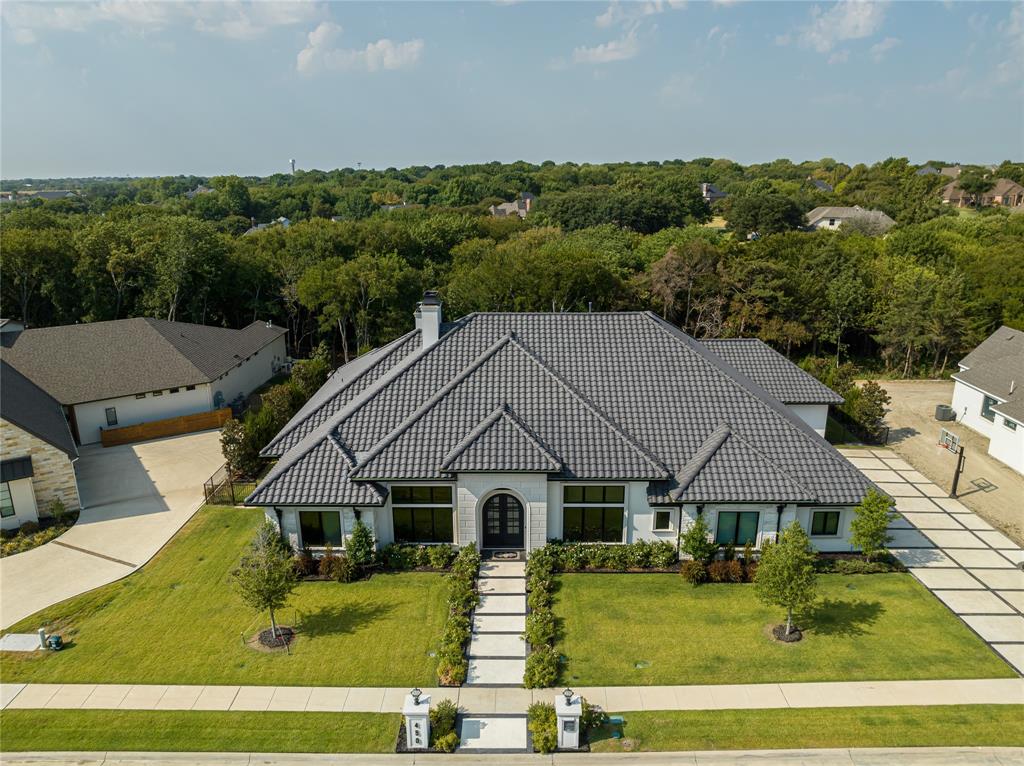 This beautiful custom built home embodies elegance and luxury. This amazing single story 5 bedroom 4.5 bath home features a 4 full car garage, outdoor shower, heated pool, spa and a putting green. Once you step inside this masterpiece you are greeted by hand scraped hardwood floors, coffered ceilings, and elegant chandeliers. A true chefs dream, featuring a 48 inch Wolf range and double oven, Built in Sub-Zero refrigerator, freezer, and a butlers pantry. Step in to the owners Retreat with access to the outdoor living space, heated floors, oversized his & hers closets which connects to the utility room that boasts 2 washers and dryers. The outdoor space is immaculate with a fireplace, grill, fridge, and  automatic patio screens to keep the Texas heat out. 450 Keystone Bend is not just a home; it is a statement of refined living. this is your opportunity to experience a lifestyle that combines opulence with comfort, and sophistication with leisure.
