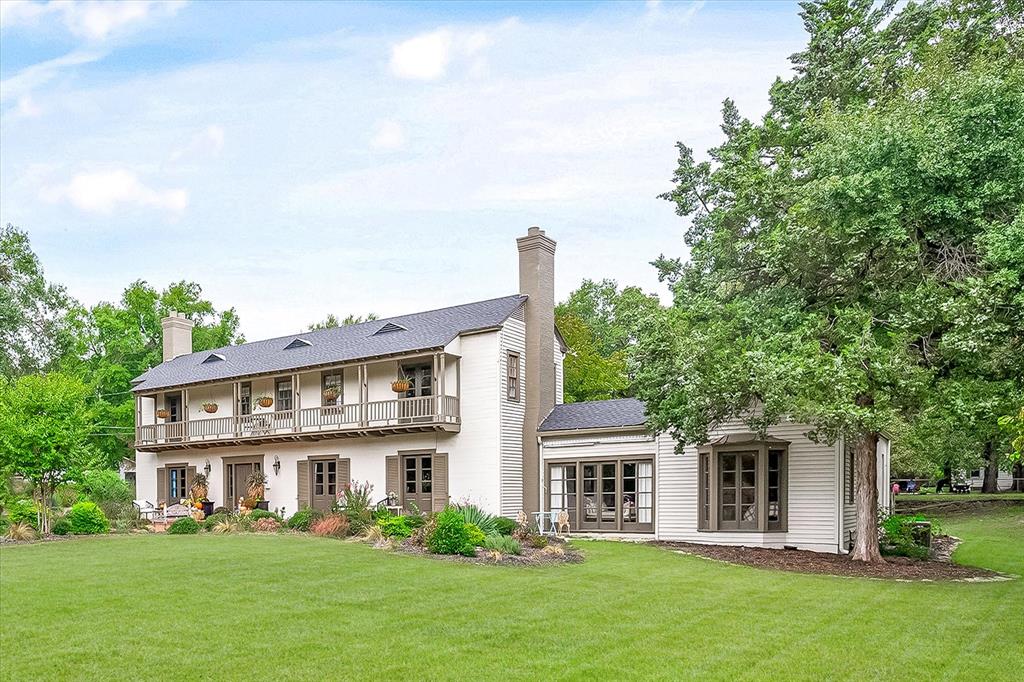Discover your historical romance in the form of the Love-Story Mansion, an exquisite Monterey Colonial-style residence. This captivating home sits on 1.4 acres in the heart of Corsicana. With over 6,000 square feet of grandeur, it still manages to maintain a warm and welcoming ambiance. The intelligently designed layout includes an open kitchen, formal dining room, a charming library, three generously-sized living spaces, a sophisticated bar, a sunlit sunroom, and a breathtaking outdoor oasis. 4 bedrooms, 2 full baths, 2 half baths, dressing rooms and effortlessly flowing spacious living spaces. Onto the expansive covered porch, the heart of this home, where you can savor sweeping views of meticulously landscaped grounds. The property's allure is amplified by the presence of mature trees and a quaint carriage house, adding an extra layer of magic to this extraordinary estate. This home is truly breathtaking with its recent restoration to showcase its original 1934 beauty and elegance!