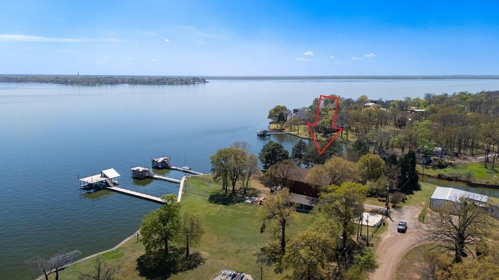 LOCATION, LOCATION, LOCATION! Discover this expansive waterfront property with an impressive 234 feet of water frontage. Enjoy stunning open water views across three adjacent southeast-facing parcels, covering approximately one-third of an acre—ideal for constructing your dream home on Cedar Creek Lake in an evolving neighborhood featuring stylish residences near the Pinnacle Golf & Country Club. This is one of the last waterfront lots surrounded by upscale homes.  This property has power and water on site  Best of all, there are no high POA fees associated with this prime area. The open water lots elegantly curve into a spacious, sheltered cove with a fishing pier, offering a total of 234 feet of waterfrontage along the 325-foot line and over 350 feet of shoreline. While utilities are already in place by the way of an old mobile home and shed  on the property.  This will need to be removed. The property features mature hardwoods and sizable crepe myrtles, enhanced by refreshing southeasterly breezes and spectacular panoramic water views. Don’t miss out on this unique opportunity to own an extraordinary waterfront property.
