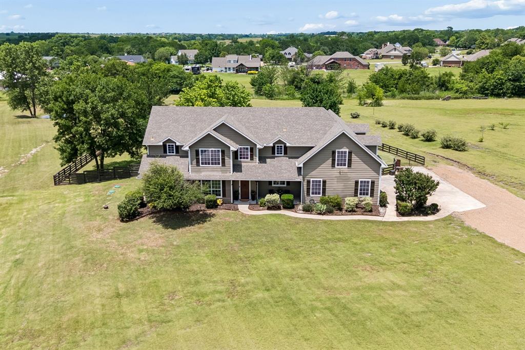 Nestled on 3.2 picturesque acres in sought after Hackberry Heights, this breathtaking property offers the perfect blend of privacy, space, & country living. Surrounded by mature shade trees & a tranquil pond, the setting creates a peaceful retreat with modern amenities.  Freshly painted throughout, this spacious 4-bedroom home offers a versatile floor plan designed for comfortable everyday living & effortless entertaining. Step into the entry to be greeted by massive windows overlooking the property in the light filled two story den. An updated kitchen boasts stainless steel appliances, including a Samsung refrigerator, a Bosch dishwasher & abundant serving & storage areas. The private first-floor primary suite serves as a relaxing retreat with its oversized ensuite bath & access to a dedicated covered porch. To round out the first floor, an office provides the perfect space for remote work or study in addition to a convenient mudroom & large laundry room. While upstairs you'll find generously sized secondary bedrooms all with walk in closets, plus two full baths & a 38X12 game room with endless possibilities for recreation, media, or gathering space. One of the home's standout features is its exceptional storage, offering significantly more storage space than typically found in comparable homes. Enjoy the beauty of the outdoors from the two spacious back porches, ideal for morning coffee or for taking in the scenic sunsets of the property. The expansive half acre+ fenced backyard area provides endless possibilities for pets, recreation, or  gardening. Additional features include new Septic system & HVAC systems, a Storm shelter in garage, a strong sense of community with neighborhood traditions & feeding into the brand new Charles and Beth Williams Elementary School. With room to roam, established landscaping, & a rare combination of acreage, trees, & a pond for fishing, 117 Galvan Lane presents a unique opportunity to enjoy your own piece of paradise in Texas.