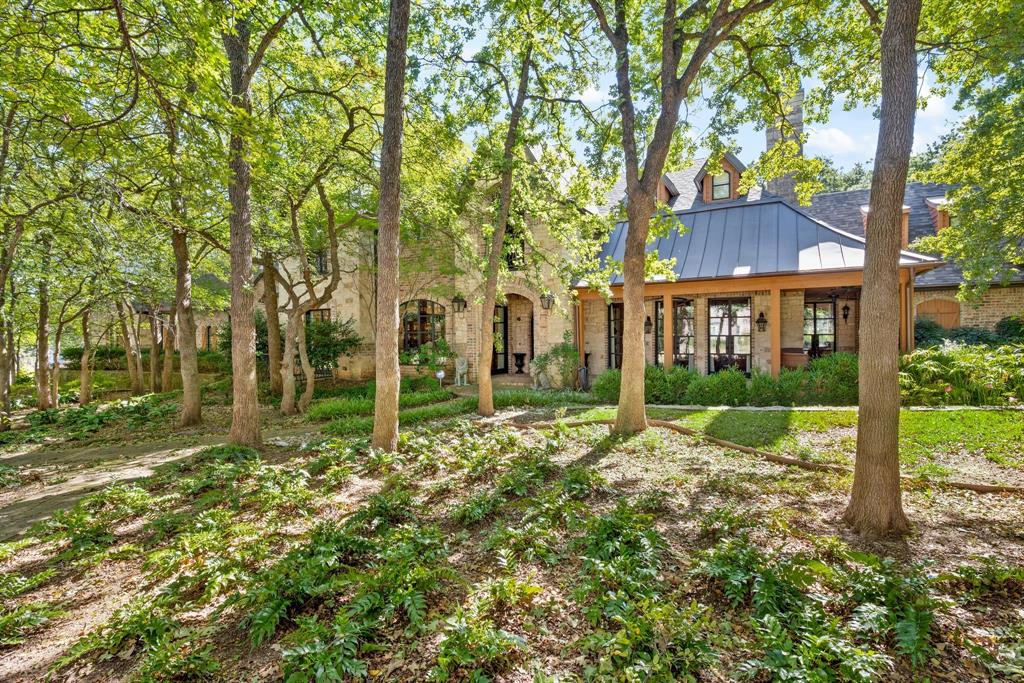 Tucked away on one of Southlake’s most picturesque and private streets, this heavily wooded estate offers a rare opportunity to enjoy the best of both worlds complete seclusion surrounded by mature trees and nature, yet just minutes from upscale shopping, dining, and the top-rated schools of Carroll ISD. This property captures the essence of Southlake living: refined luxury in a peaceful, natural setting with no HOA restrictions.
As you enter the long, tree-lined drive, the home reveals itself quietly, set back from the street for ultimate privacy. Towering trees and lush landscaping frame the residence, creating a sense of tranquility and exclusivity from the moment you arrive. Designed with both comfort and elegance in mind, the home features an open-concept floor plan with expansive living areas, perfect for entertaining or relaxing with family. High ceilings, large picture windows, and seamless indoor-outdoor flow bring the beauty of the surrounding woods into every room.
The main level is anchored by a spacious living area that opens to the kitchen and dining spaces, blending natural light and warmth throughout. Every detail has been thoughtfully designed to balance function and luxury, from the architectural finishes to the layout that allows for comfortable daily living and effortless hosting.
Step outside to discover a backyard oasis designed for relaxation and play. The sparkling pool is nestled beneath the trees, offering a serene escape on warm Texas days. There’s ample open space for outdoor games, gatherings, or even future additions all surrounded by nature’s beauty and total privacy.
For car enthusiasts or those needing extra storage, with over 2000 sq feet the garage provides exceptional versatility of space, whether for vehicles, hobbies, or a workshop. The property’s peaceful setting, flexible design, and convenient location make it truly one of a kind.
