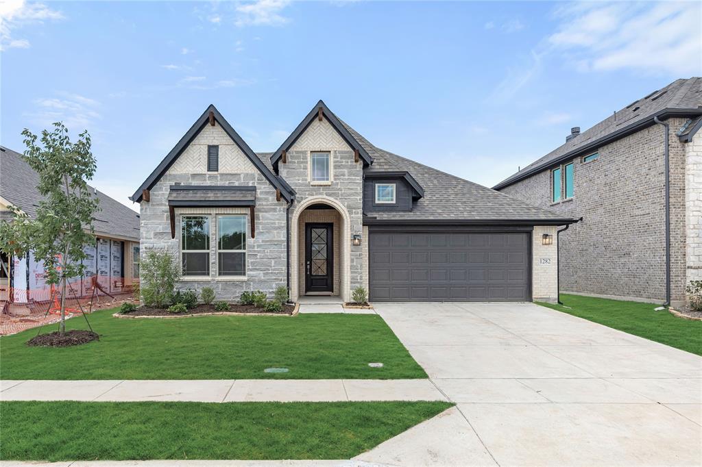 NEW! NEVER LIVED IN. Meet the Jasmine by Bloomfield Homes in Anderson Crossing — the perfect one-story floorplan offering 4 bedrooms and 3 baths in a layout that feels both open and effortlessly functional. From the moment you come through the foyer, the home feels bright and welcoming as you enter the family room centered around a wood-burning tile-to-mantle fireplace that brings warmth and character to the space. Whether it’s cozy evenings in or hosting friends, this room delivers comfort with style. The Deluxe Kitchen is ready for everything from weeknight dinners to holiday gatherings, featuring quartz countertops, built-in stainless steel appliances, and a layout that connects seamlessly to the dining and living areas. RevWood flooring flows through the main living spaces, adding durability and a rich, natural look that ties everything together beautifully. The primary suite offers a relaxing retreat with a spacious bedroom and a well-appointed bath that includes a huge walk-in closet, linen closet, garden tub, and a vanity with separate sinks. 3 secondary bedrooms are thoughtfully arranged near 2 full bathrooms and the utility room, providing flexibility. The brick and stone exterior is complemented by professional landscaping that enhances the home’s curb appeal, while full rain gutters add practical protection and long-term performance. Community amenities at Anderson Crossing include a playground, covered pavilion, and picnic areas that encourage outdoor living and neighborhood connection. If you’ve been searching for the ideal one-story home that blends comfort, function, and thoughtful upgrades, the Jasmine is ready to impress. Ready to make it yours? Visit Anderson Crossing and explore the Jasmine today!