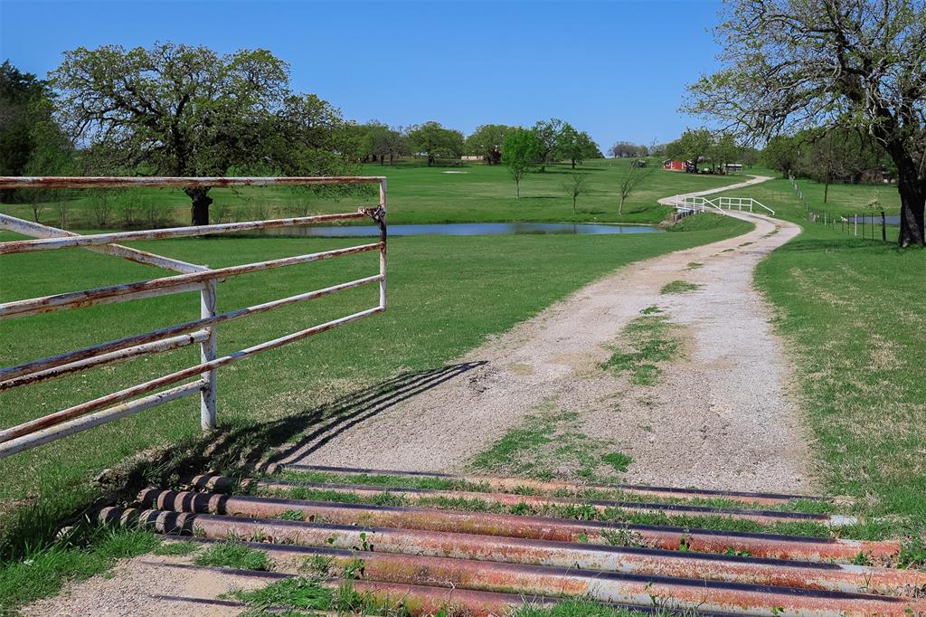 Discover this beautiful 21 acre estate just outside the city limits, offering the perfect blend of country living with convenience to town. The property’s picturesque topography is highlighted by a large stock pond at the entrance, complete with a metal bridge that provides a grand drive up approach to the home. At the heart of the property sits a very well maintained brick home, providing comfort and charm. This home offers a spacious living room that seamlessly flows through the dining room and into the large eat in kitchen. 
A finished tiny home next to the main residence adds versatility. Ideal as in law quarters, a private guest retreat, or a home office. Those needing workspace, this property boasts a large workshop with concrete floor and utilities, along with multiple outbuildings and stables ready for horses and other livestock.
Adding to the appeal, the land includes an unfinished barndominium, already framed and ready for your personal touch whether you envision extra living space, rental potential, or a custom entertainment area.
This one of a kind property offers endless opportunities; country living, working, and entertaining all in one place.