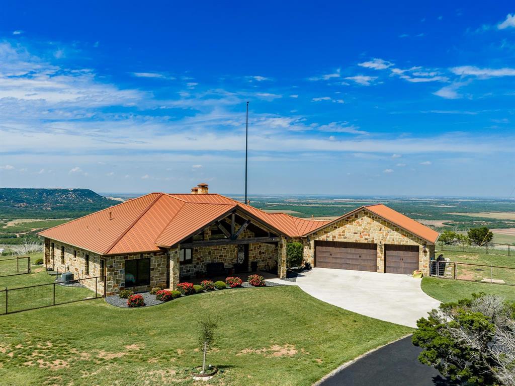 Round Top Mountain is one of Taylor County’s most extraordinary offerings, featuring over 400 acres of dramatic elevation, panoramic views, and a custom Turner Custom Home built in 2019 high above the surrounding countryside. With elevations from approximately 1,980 feet to 2,340 feet, the property delivers a true mountain setting without leaving Texas.

The 2,922 square foot home offers 3 bedrooms, 2.5 bathrooms, a 3 car garage, soaring beams, two rock fireplaces, expansive glass, and upscale finishes designed to capture the breathtaking scenery. The recently paved road provides convenient access to this private retreat.

The land features rolling terrain, trails, native cover, scenic overlooks, stock tanks, and Little Elm Creek along the north boundary, creating outstanding appeal for ranching, recreation, hunting, or long term investment.

A rare opportunity to own a legacy property unlike anything else in Taylor County.

Buyer and buyer’s agent to verify acreage, square footage, utilities, water, taxes, schools, and all property details.