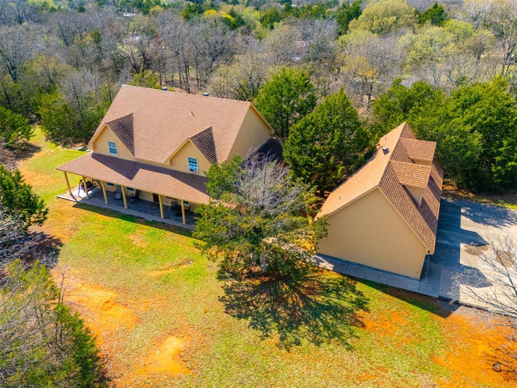 REDUCED PRICE! Private 10-Acre Retreat with Custom Home, Guest Apartment & Endless Space to Gather. If you’ve been dreaming of privacy, nature, and room to spread out—this exceptional custom estate delivers it all. Tucked among mature trees, this property offers the perfect blend of peaceful seclusion and thoughtfully designed living spaces. A remote gated entrance and long drive lead you to a spacious motor court, providing abundant parking for guests, boats and recreational vehicles. Step inside and you’re welcomed by a grand foyer flanked by two versatile spaces—a private owner’s study on one side and a game room or gathering space on the other. At the heart of the home, the expansive main living room flows seamlessly into the kitchen and breakfast area, creating an ideal setting for everyday living and entertaining. The chef-inspired kitchen features dual prep islands, generous cabinetry, and a breakfast bar designed for casual dining and conversation. Just beyond, the formal dining room is bathed in natural light from a wall of windows overlooking the surrounding woods. The primary suite on the main level offers a peaceful retreat with a spa-like bath featuring dual vanities, a Jacuzzi soaking garden tub, and a separate shower. Upstairs, a second primary suite provides an ideal setup for extended guests or multigenerational living, accompanied by two additional bedrooms, a full bath, a media room or flex space, and a bonus storage room for hobbies and gear. Above the garage, a separate private apartment with its own entrance includes a bedroom, full bath, and kitchenette—perfect for guests, rental potential, or a private studio. Step outside and you’ll discover expansive covered tiled patios at both the front and back of the home, perfect for outdoor dining, entertaining, or enjoying quiet mornings with coffee while taking in the natural beauty around you. With 10 acres of wooded tranquility and Lake Alvarado, this property offers space and privacy.