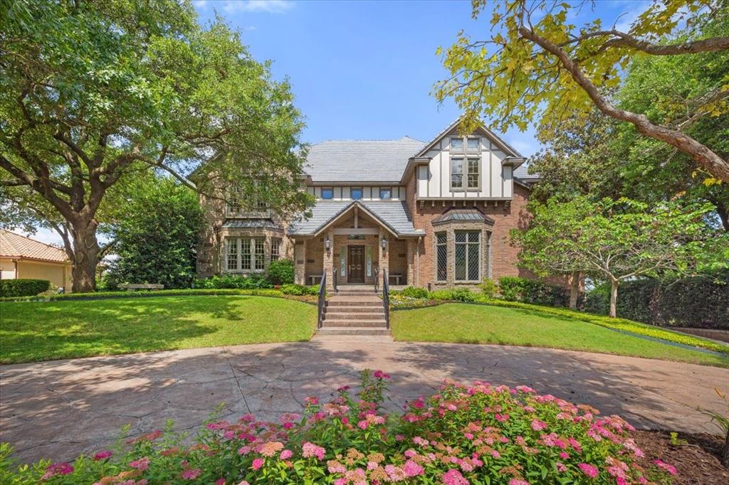 Incredible views abound from this beautiful traditional home of English Tudor style on a quiet, tree-lined cul-de-sac in prestigious gated and guarded Mira Vista. The home overlooks the redesigned and almost completed Mira Vista Golf Course and the horizon for miles beyond.  Walls of windows along the entire back of the home provide natural light to all living areas. The home has recently been artfully staged with many updates. The home offers approximately 8,500 square feet of living area plus an additional 1,000+ square feet of air conditioned flex space as well as garage space for 5 cars with an IV charger. ~~The home consists of four levels, each presenting an opportunity for you to curate the space for your family's lifestyle. The formal living, dining, library, and office are on the first level as well as the kitchen, breakfast area and laundry room which have access to a balcony. ~~A family room on the second level has an interior balcony, a perfect place to display works of art. A unique viewing observation room, where a telescope currently resides, adjoins the family room and provides great star-gazing and relaxation. The second level also encompasses the spacious primary bedroom and luxurious ensuite bathroom. The other two bedrooms, each with ensuite bathrooms, are separated from the primary bedroom. ~~On the lower level, a game room boasts a rustic fireplace created from fossil rock excavated on the building site. A fully equipped exercise room is adjacent to the game room. The approximate 1,000 SF of air conditioned flex space includes an unfinished media room and a workshop. The 5 car garages on this level include an EV charger and a dumbwaiter to carry items from the garage to the kitchen hall on the first level. Please see: About 6908 Ridgewood Dr From The Seller posted in Documents.